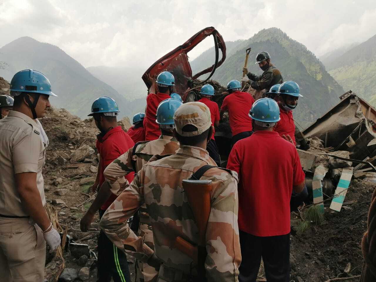 Diggers are used to search for several vehicles caught up in a landslide 