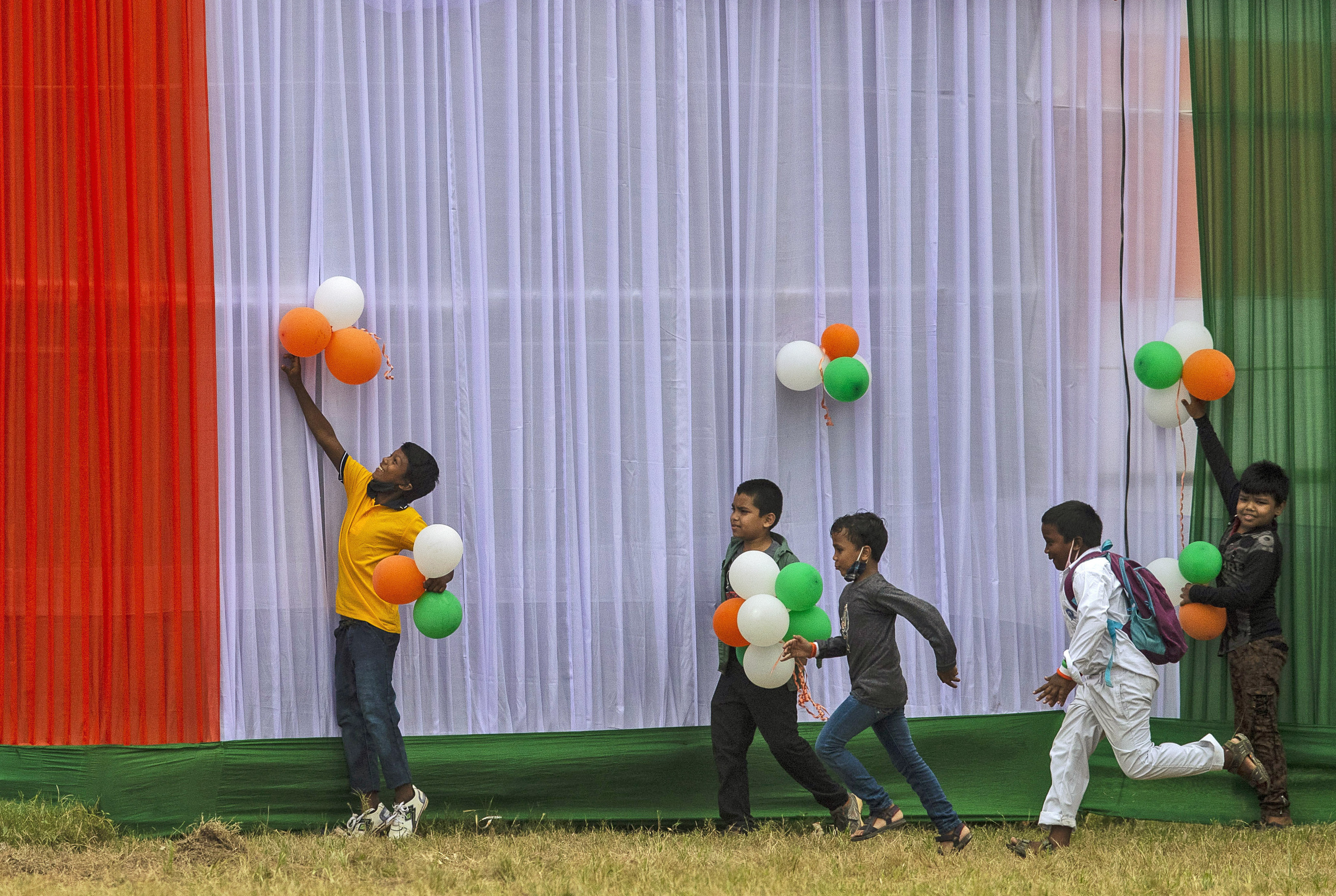 Children collect balloons used to decorate the venue of Independence Day celebrations in Gauhati, India