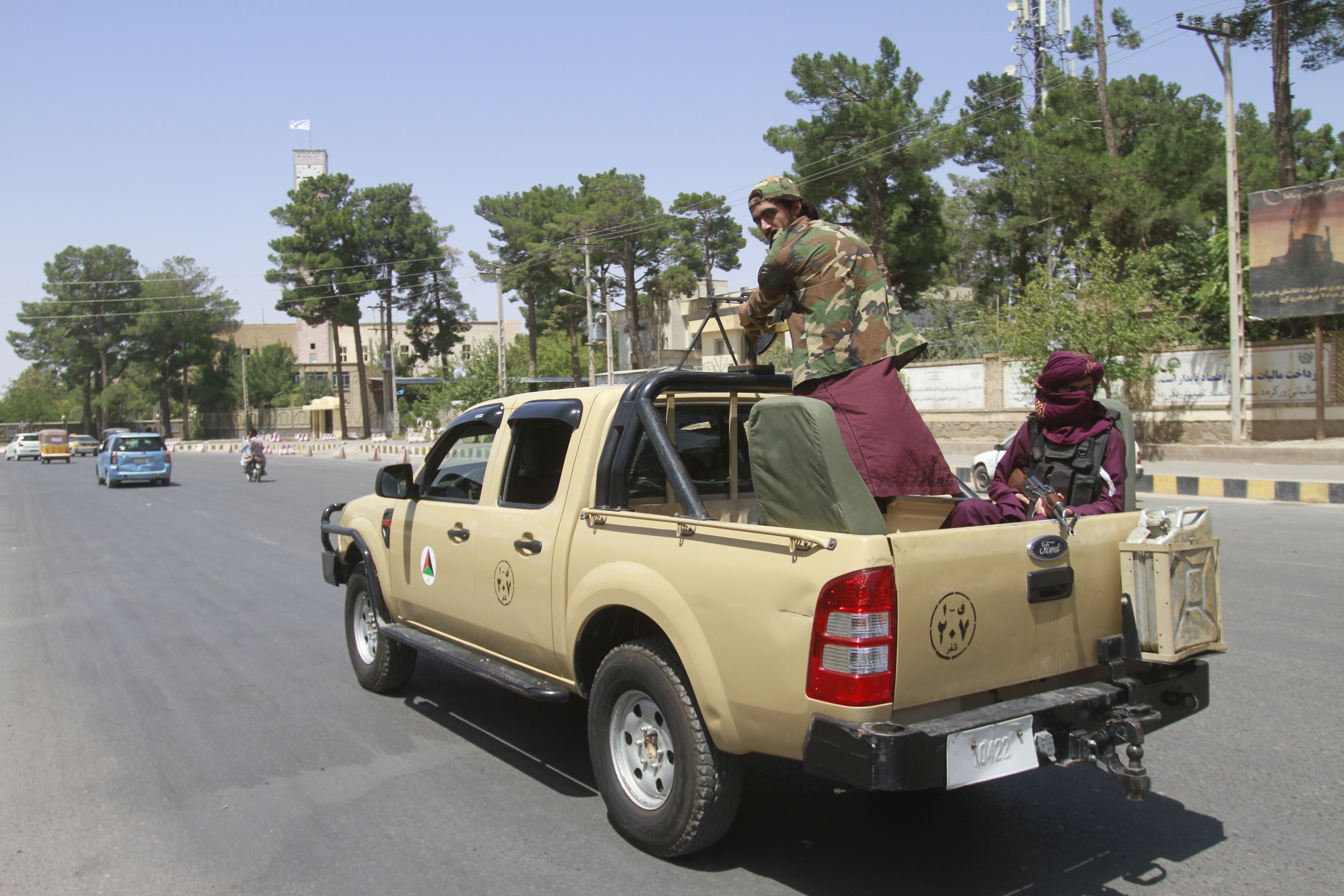 Taliban fighters sit on the back of a vehicle in the city of Herat, west of Kabul, Afghanistan