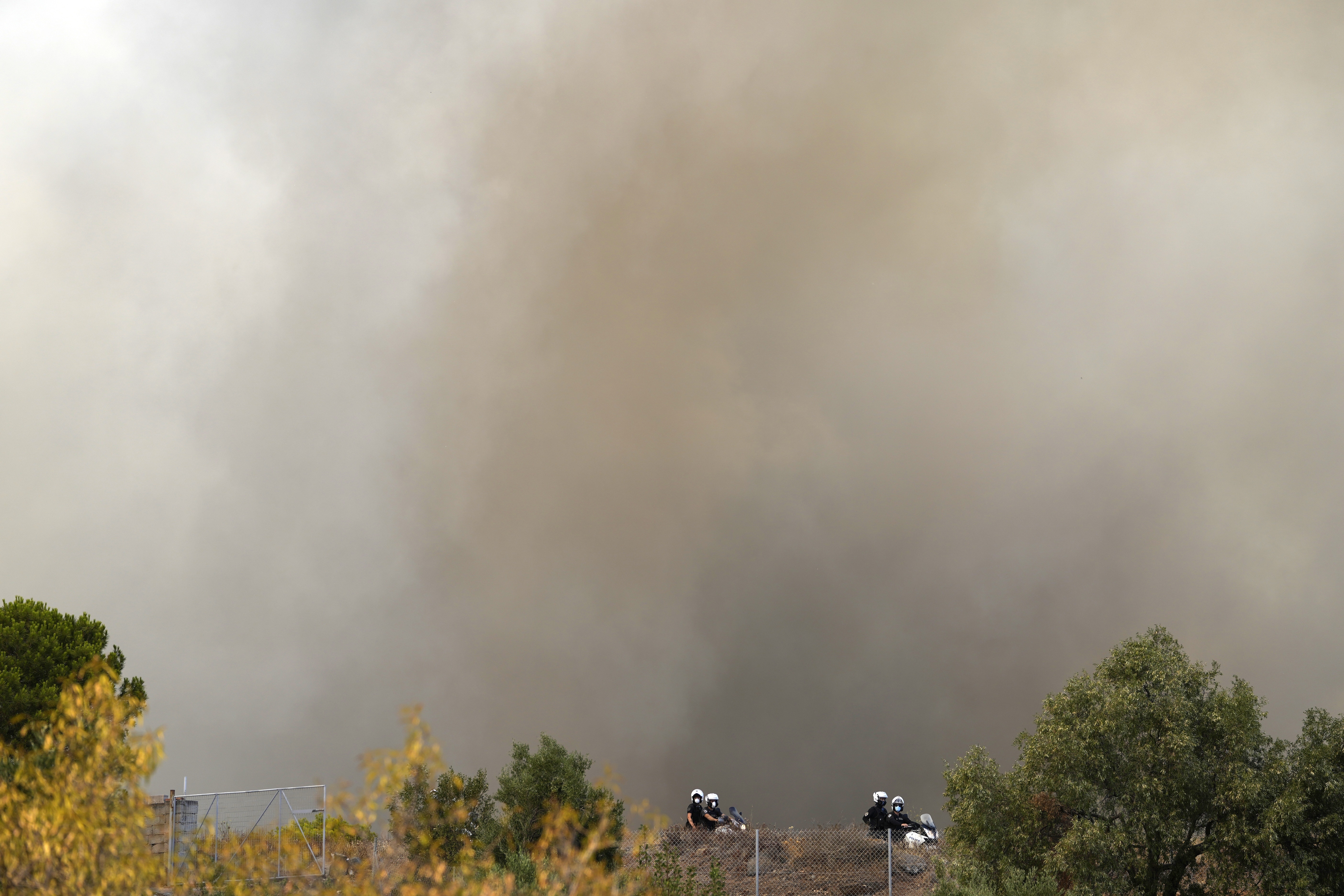 Police patrol during a wildfire  (Thanassis Stavrakis/AP)