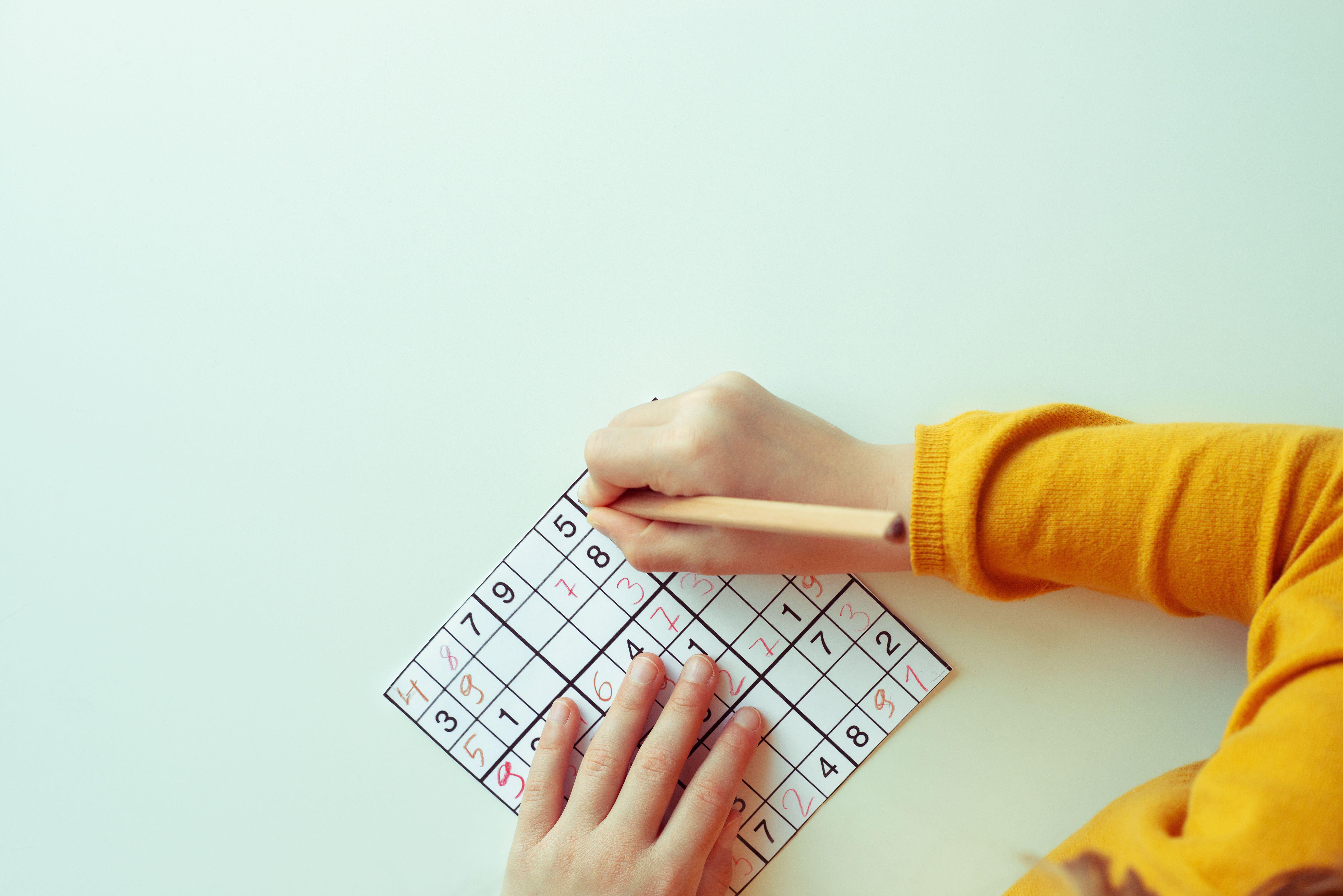 Person doing a sudoku puzzle