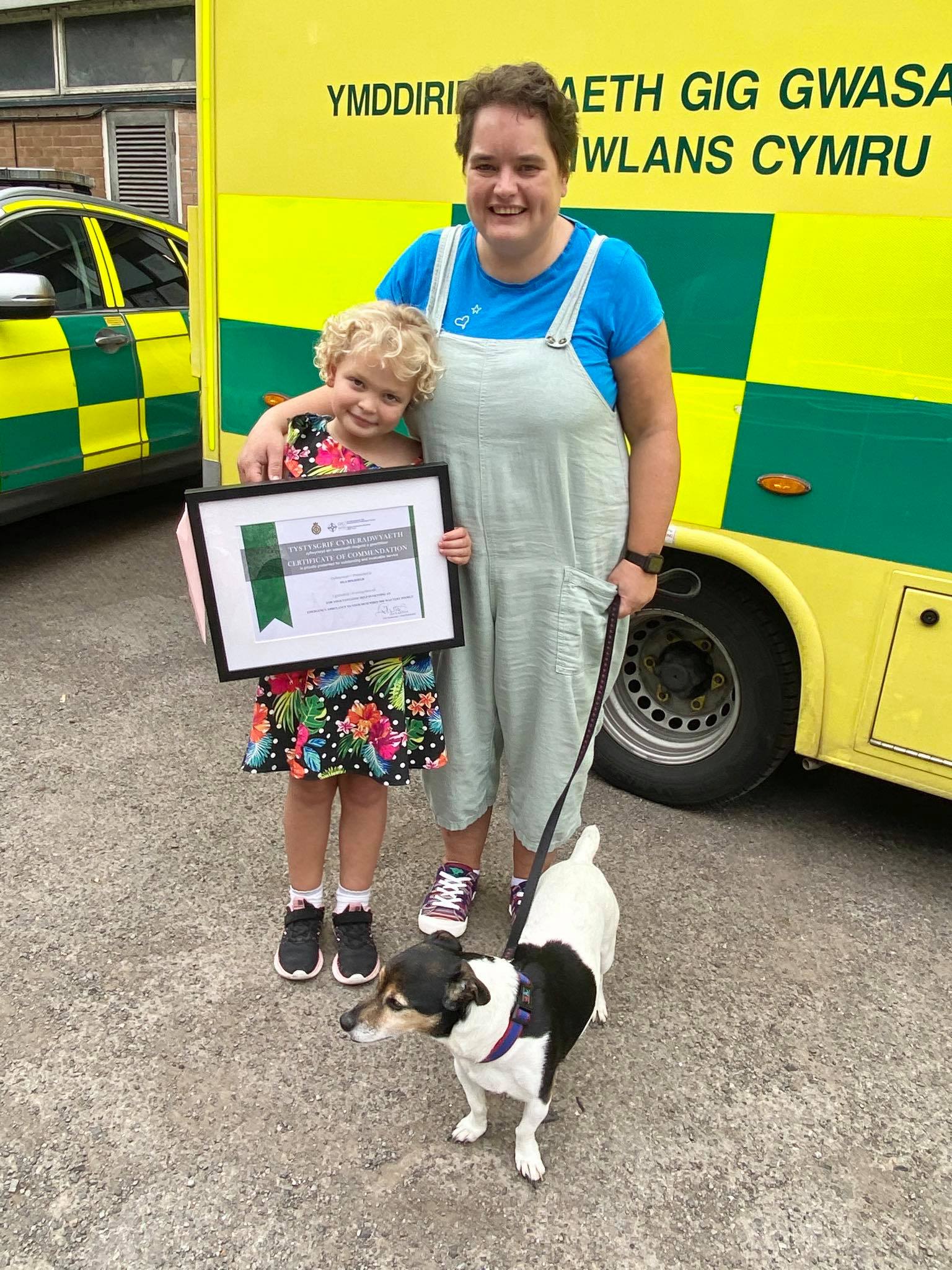 Isla Holifield with her mother Katherine and their dog Roly after being presented with her certificate of commendation (Welsh Ambulance Services NHS Trust/PA) 