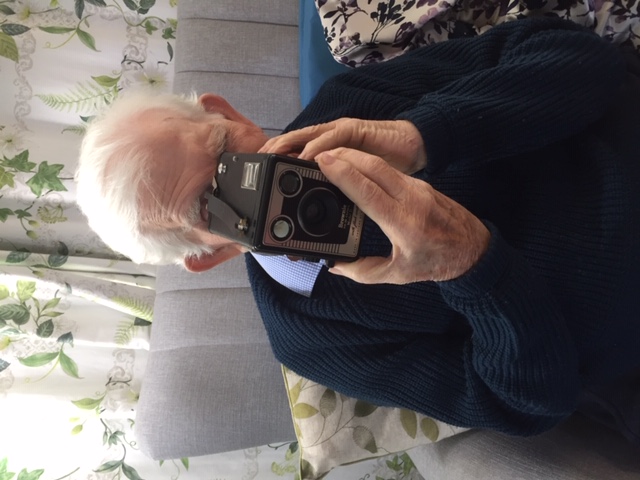 A care home resident using a camera from one of the memory boxes