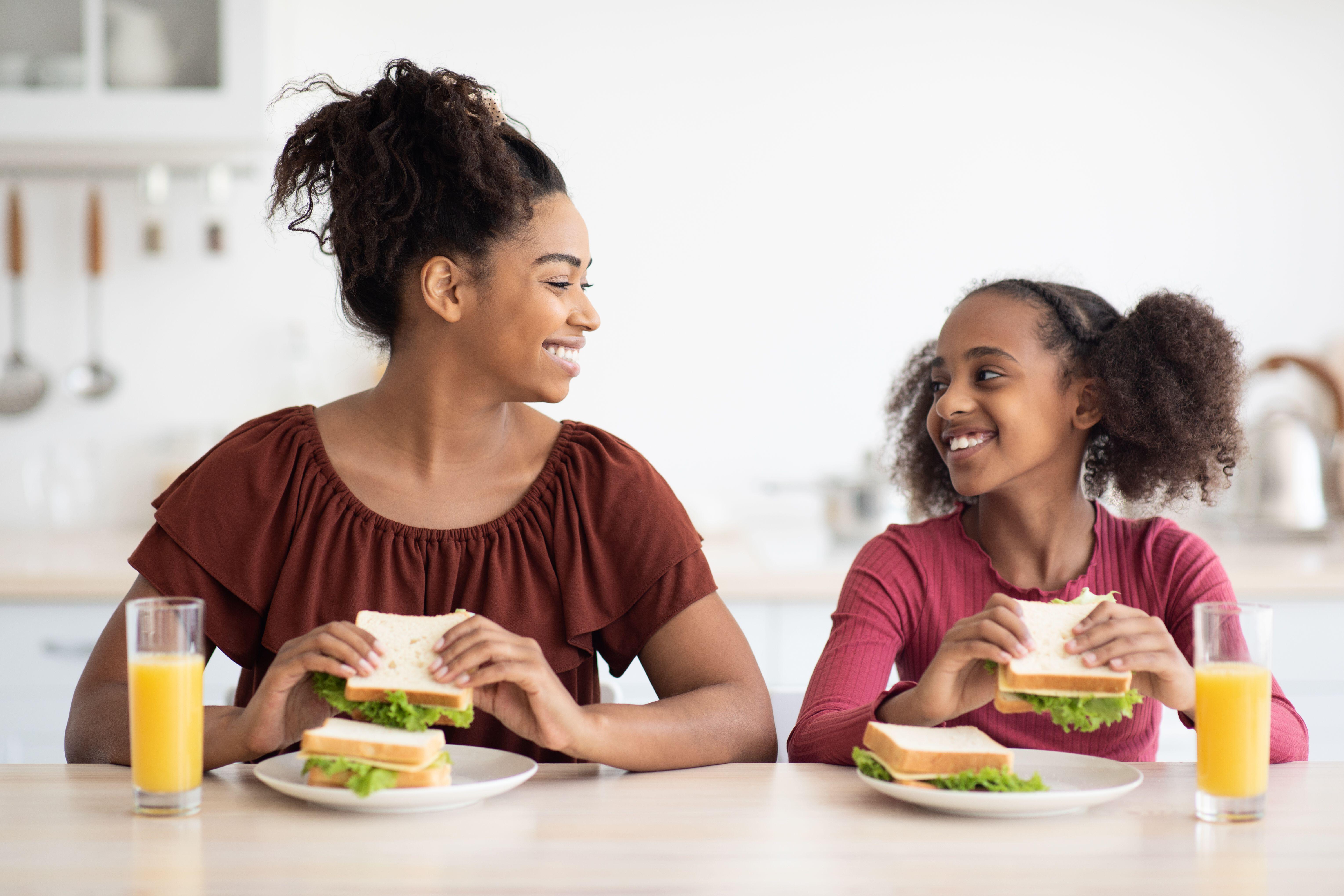 Mother and daughter eating sandwiches