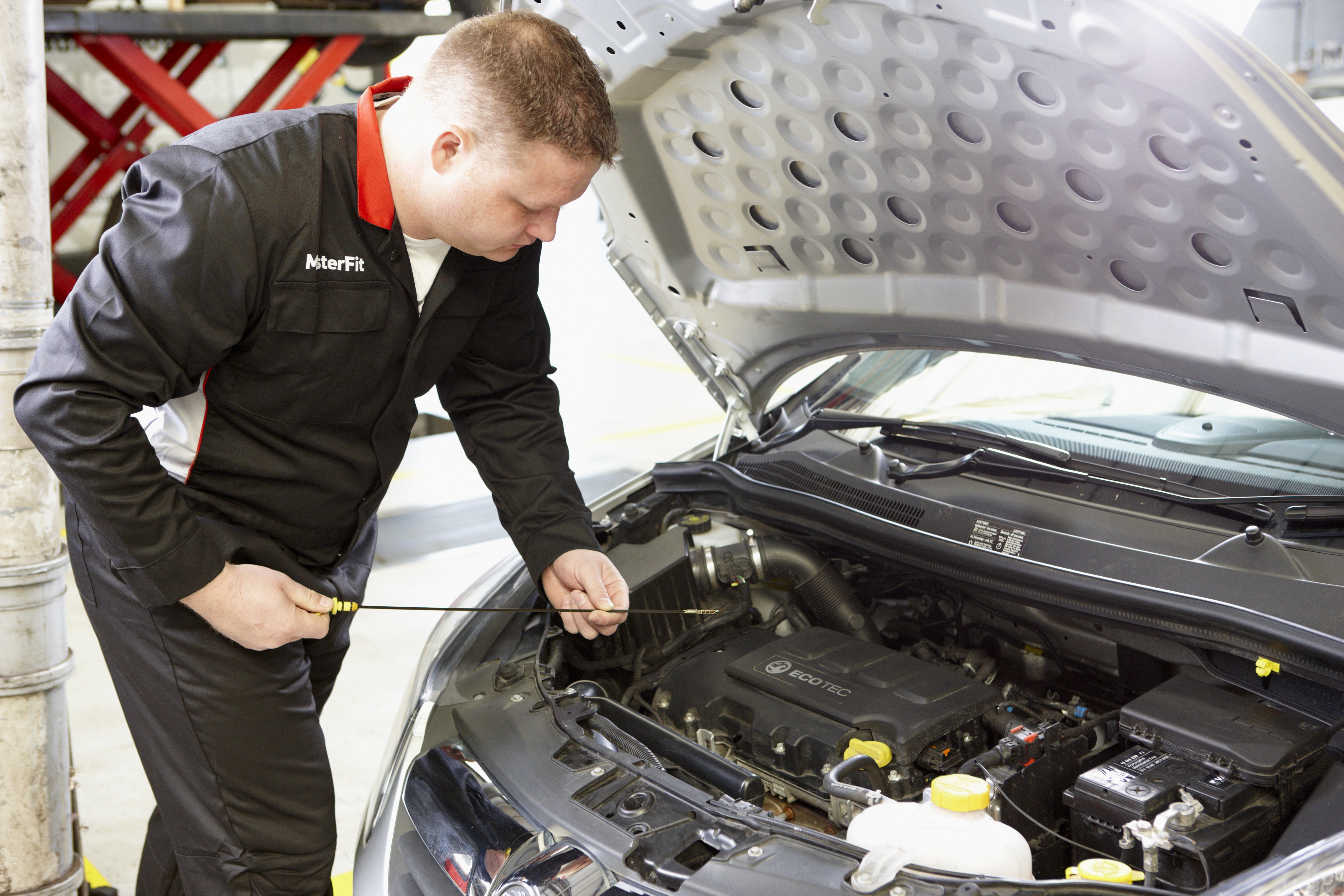 Mechanic checks car oil