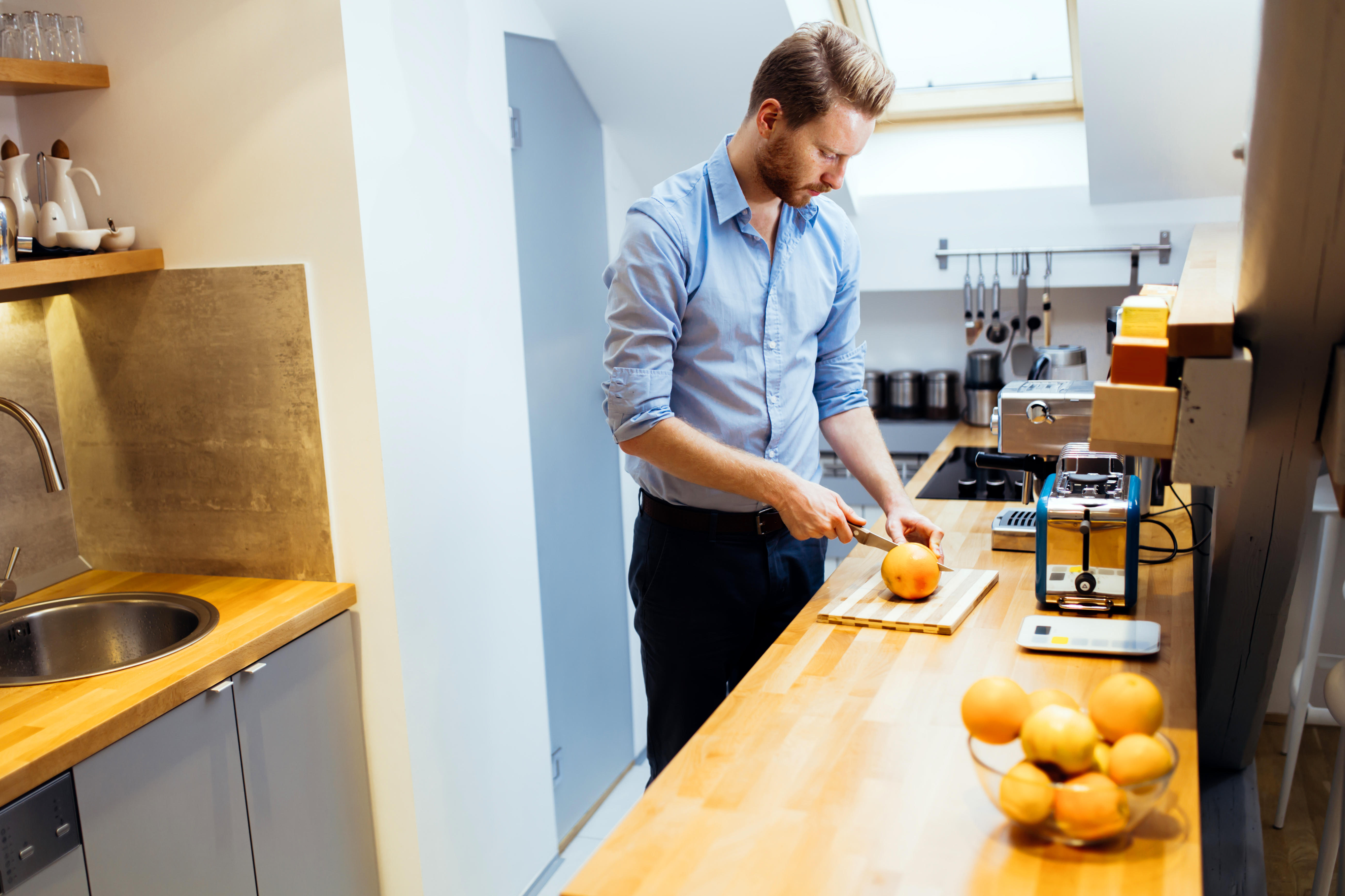 A man chopping an orange