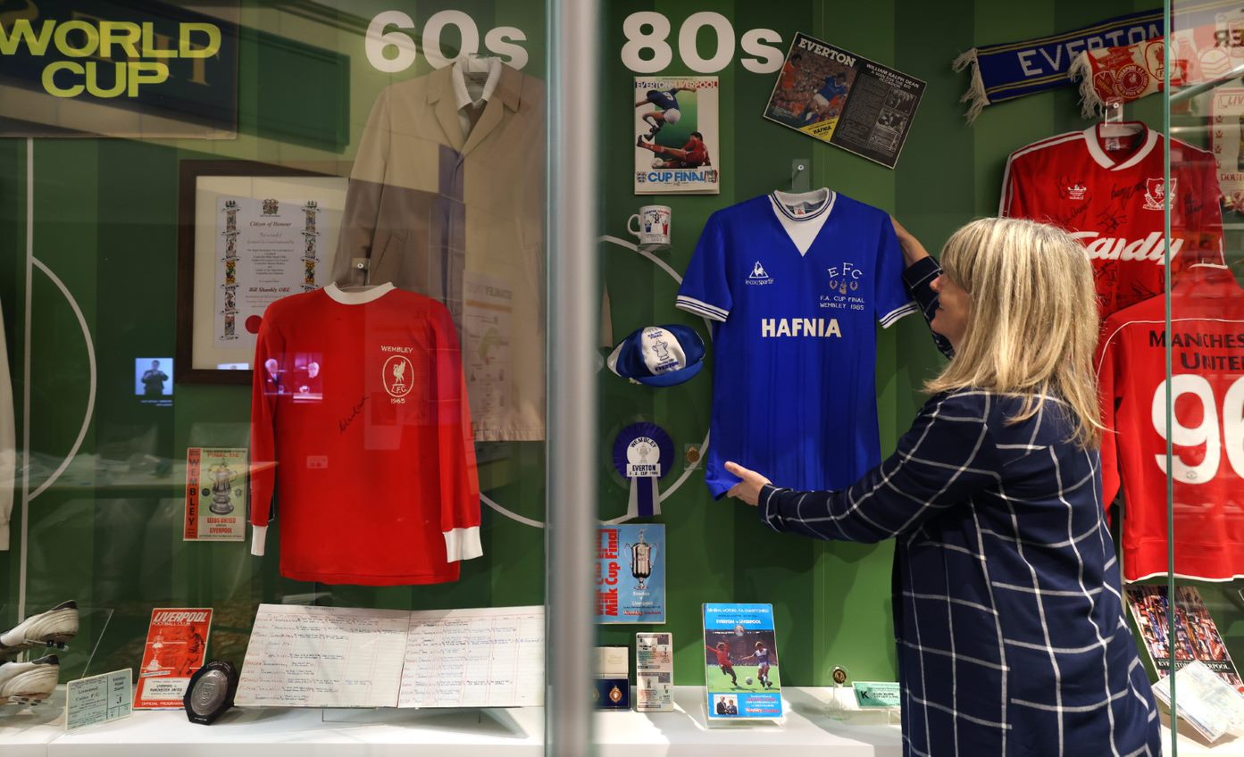 Curator Sharon Brown puts final touches to a football display case at the Museum of Liverpool's Wondrous Place gallery (Gareth Jones/PA)
