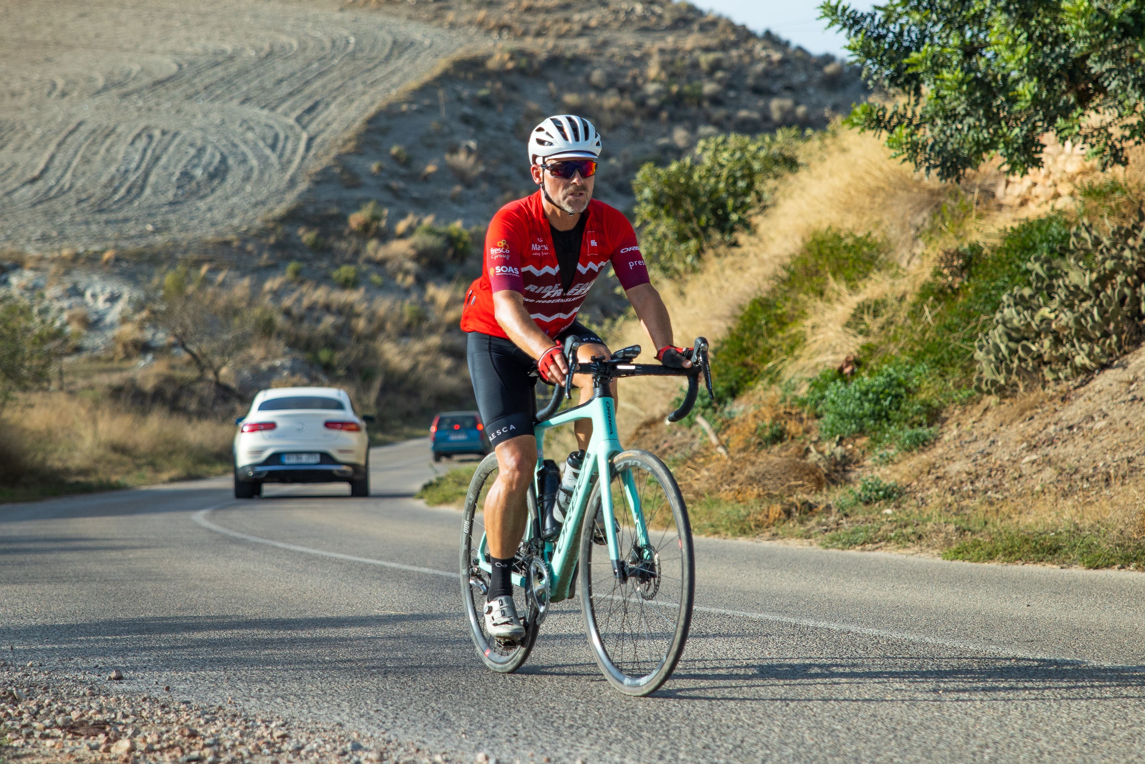 Gordon Miller cycling along a road in Spain.