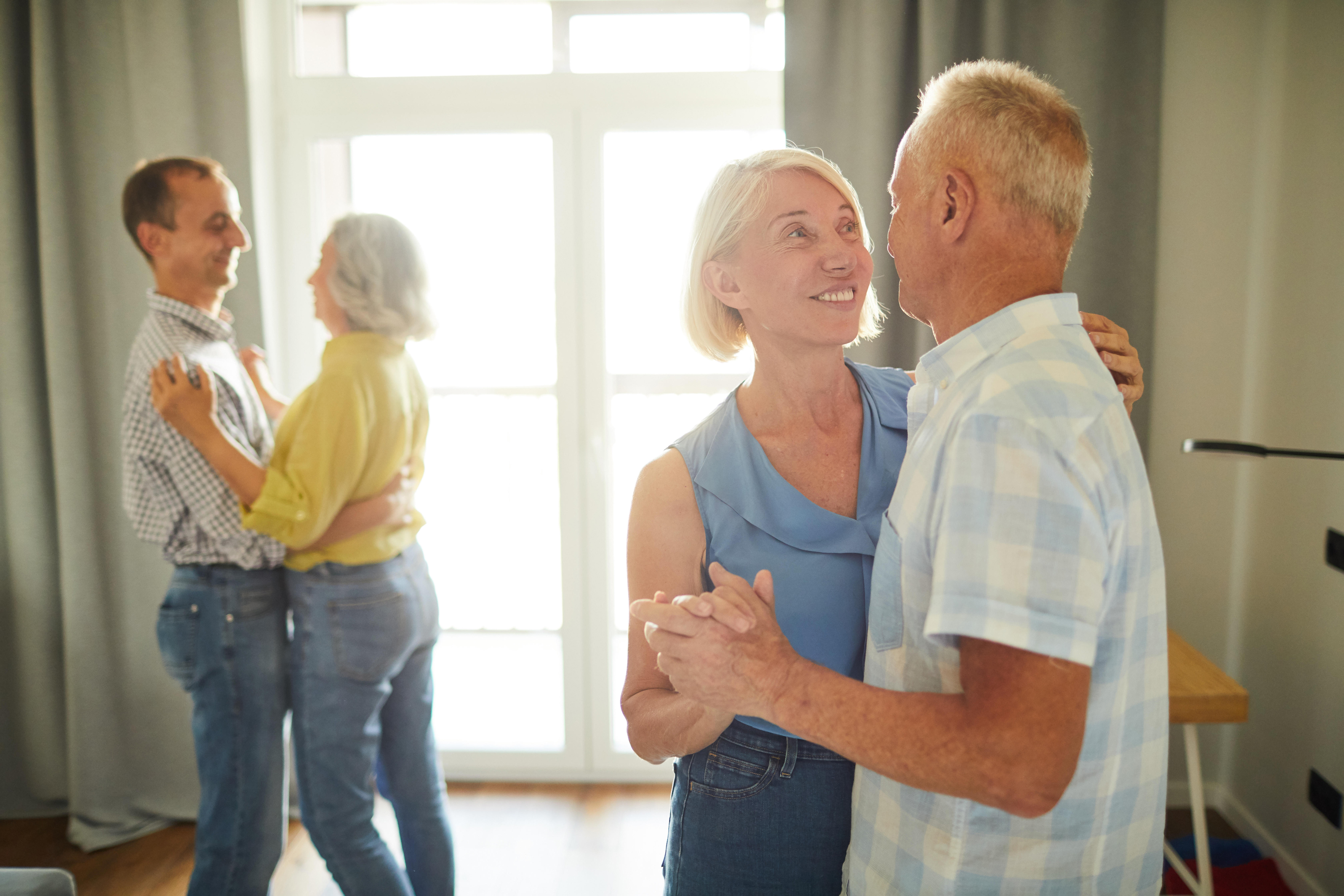 Two senior couples dancing romantically 