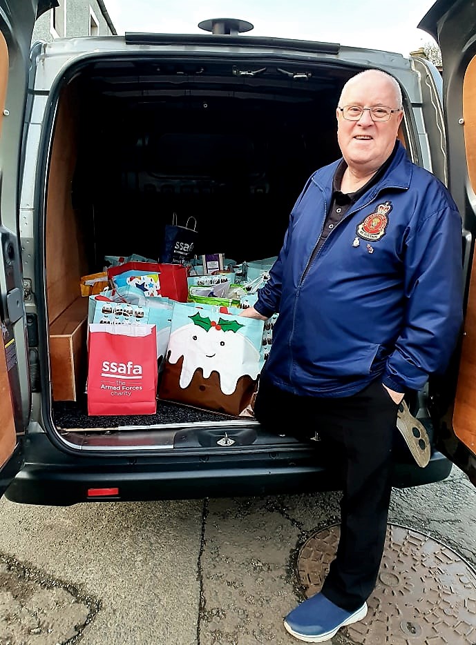 SSAFA Edinburgh volunteer Billy Walker standing by an opened car boot, with gifts in the boot.