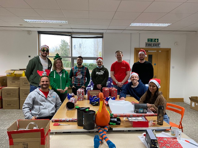 Santa Stork volunteers stood next to all the presents