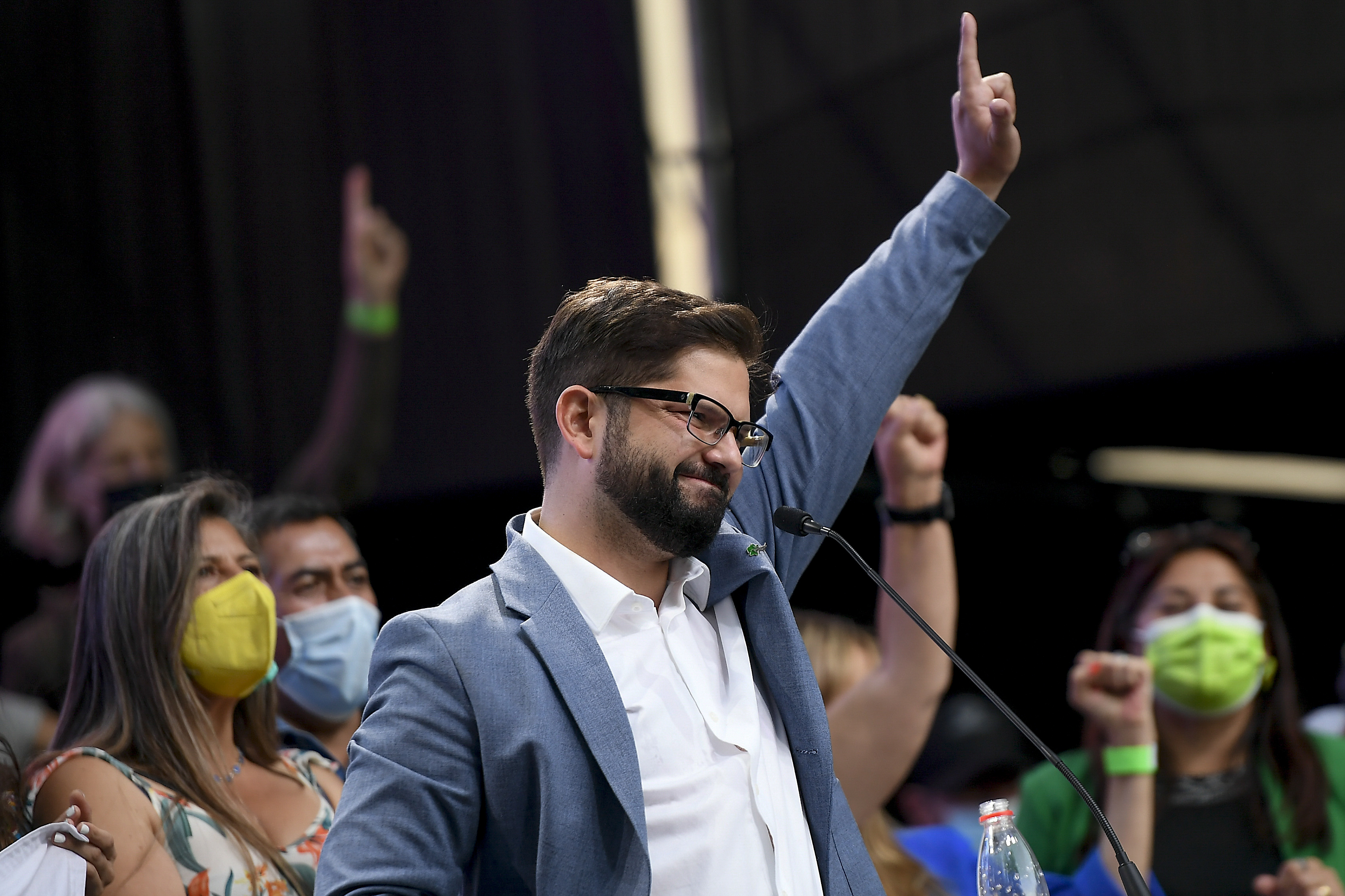 Gabriel Boric waves to supporters at a campaign rally