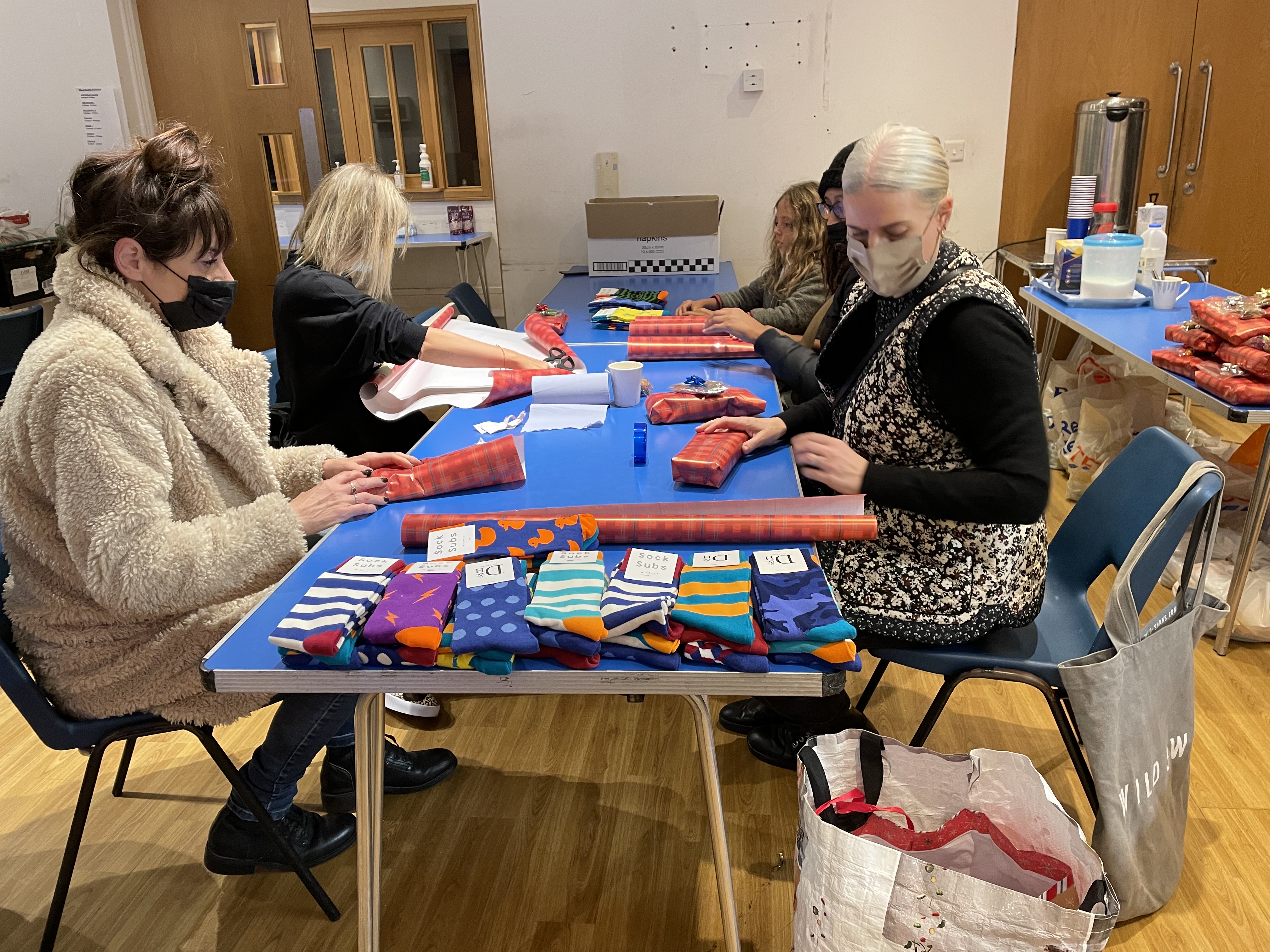 Volunteers wrapping socks to give to guests.