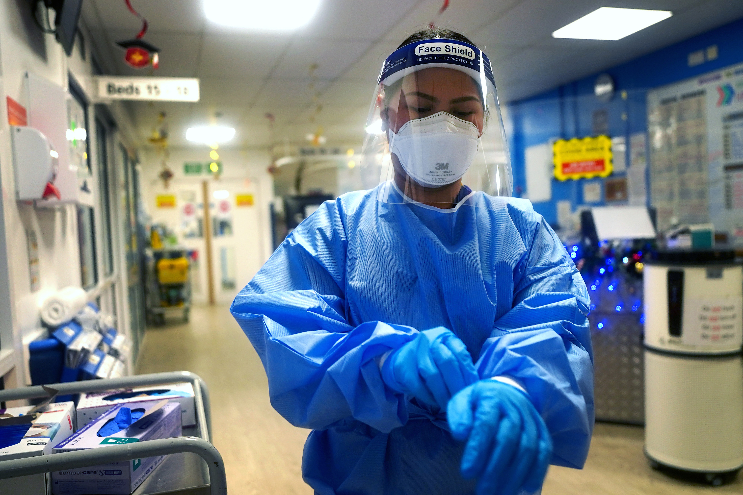 A nurse puts on full PPE  