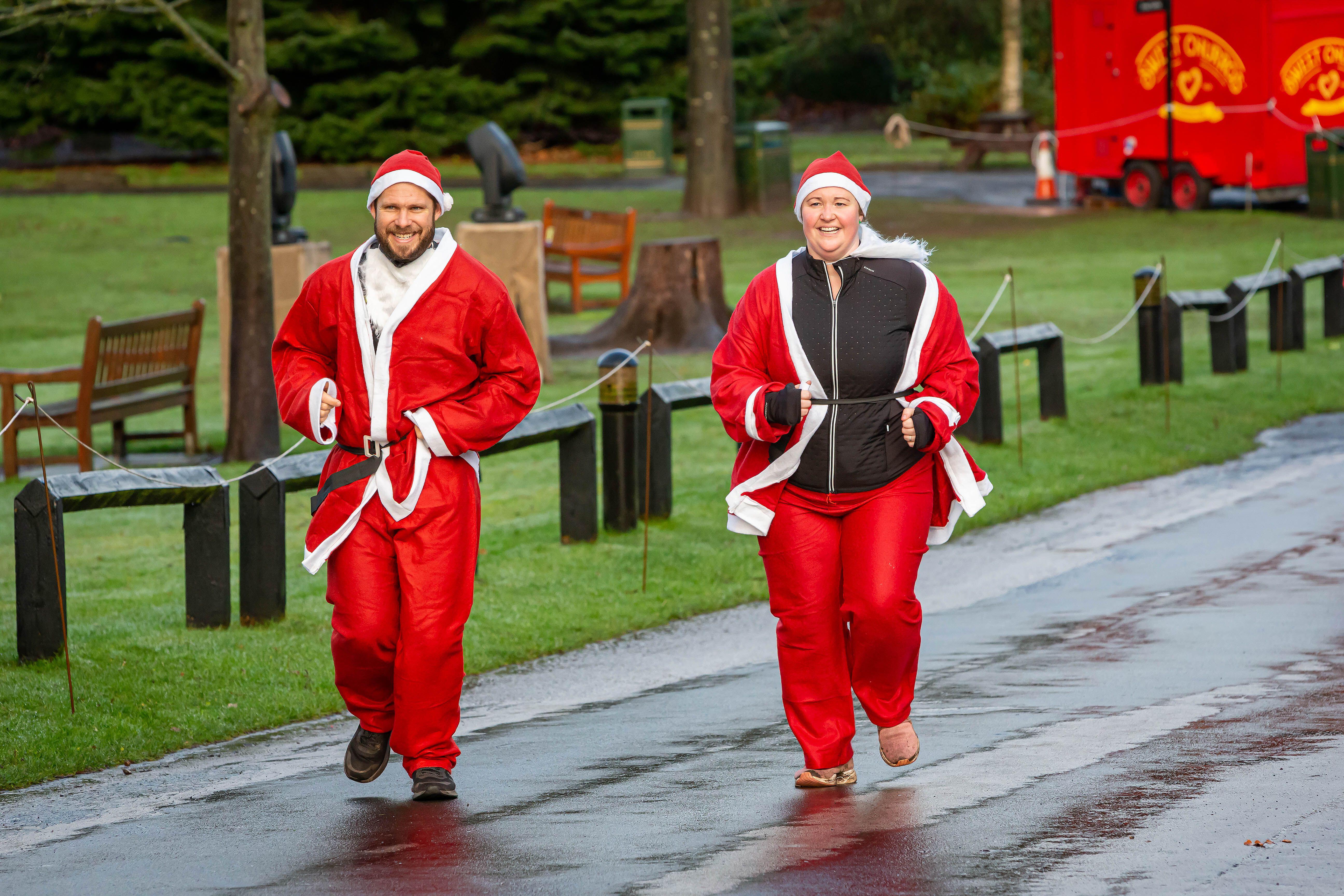 A couple dressed as santas running in a santa dash