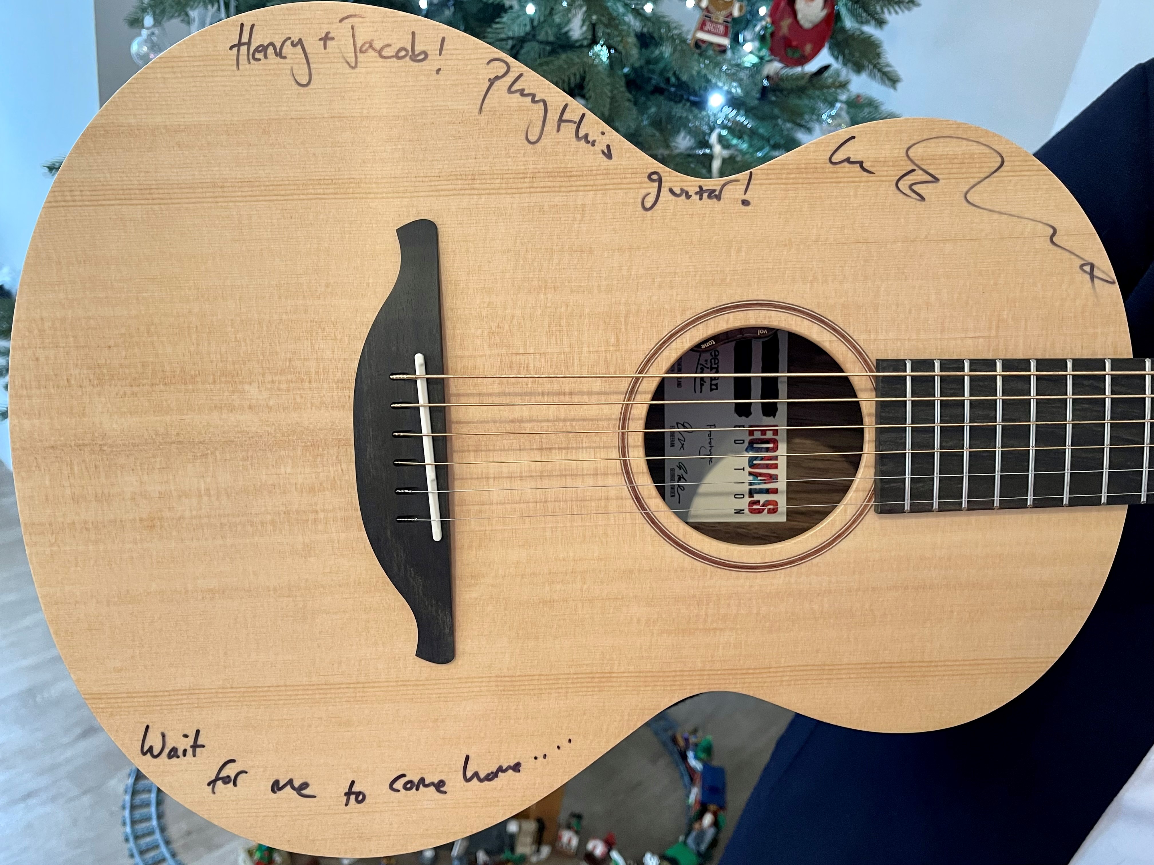 Ed Sheeran wrote ‘Henry + Jacob! Play this guitar!' on the instrument, personalising it for the charity raffle winners. (GeeWizz/ PA)