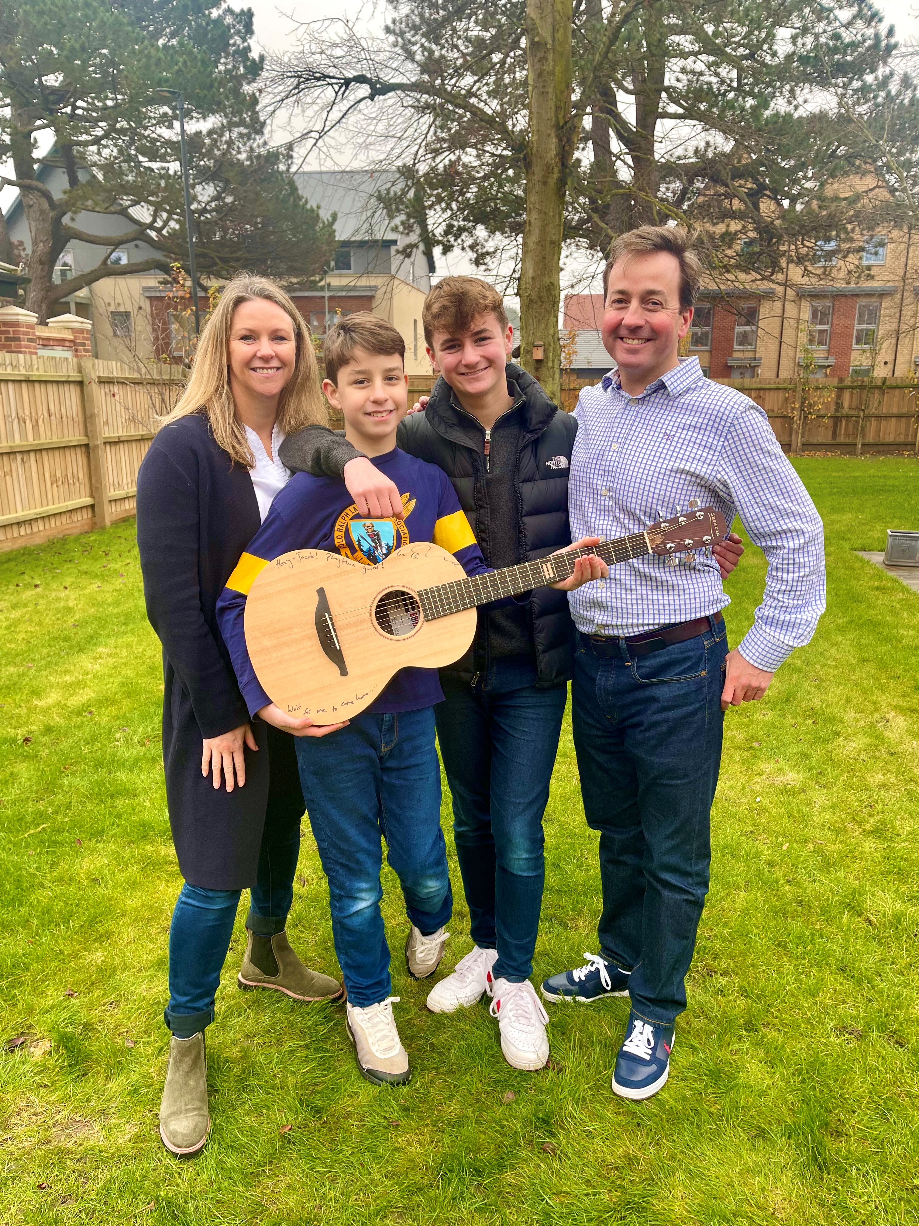 Hospital worker Kellie Myers and her family with Ed Sheeran's prototype guitar, that they won through a charity raffle. (GeeWizz/ PA)