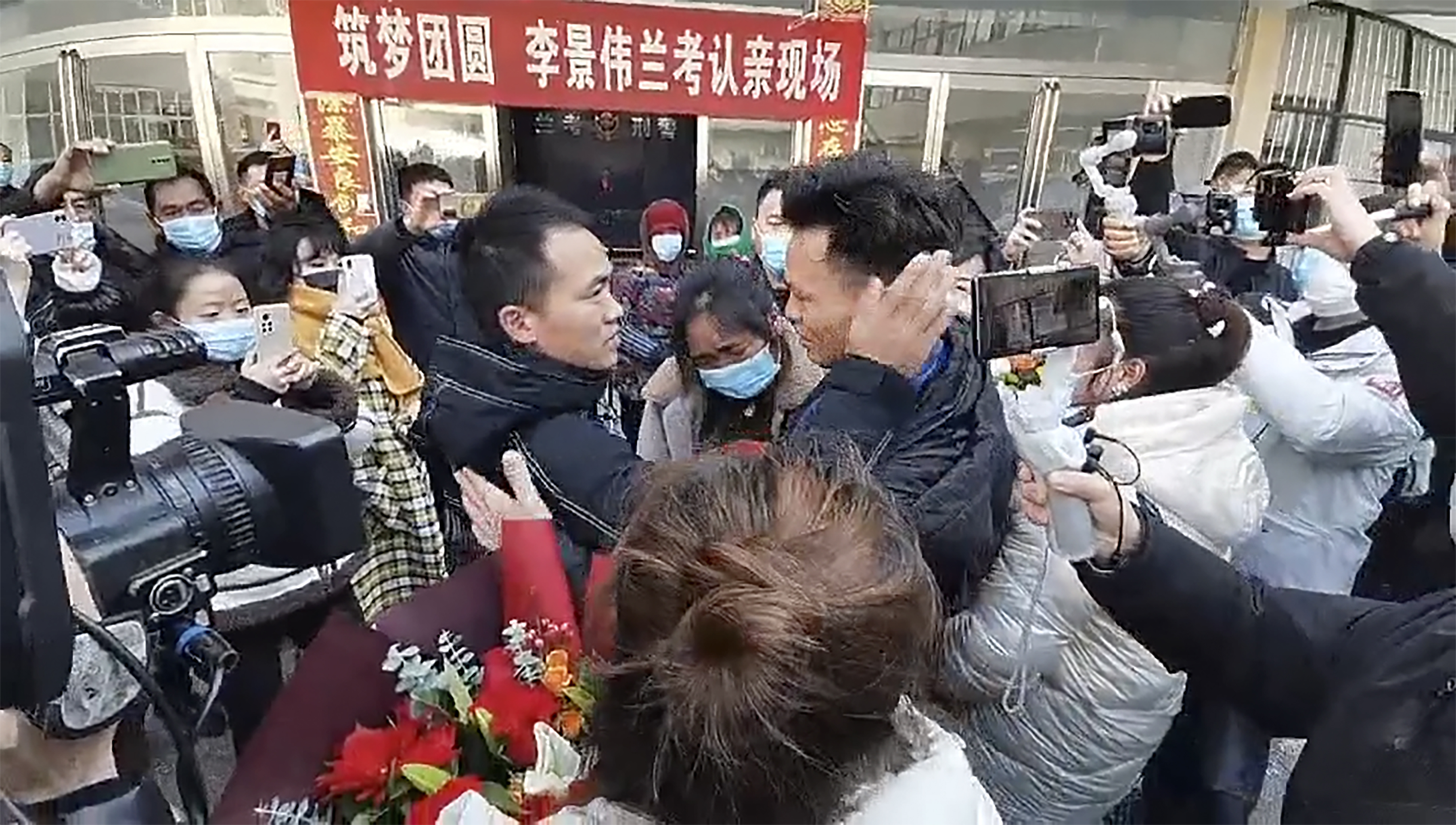 In this image taken from video, Li Jingwei, right, is reunited with his mother, centre, and other relatives in Lankao in central China's Henan Province