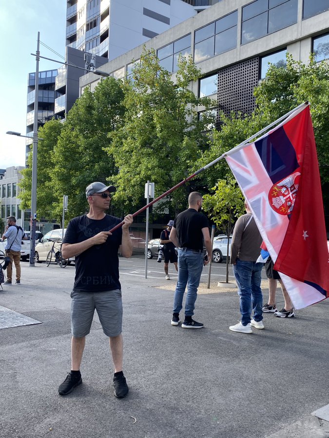 A Novak Djokovic supporter waves a Serbian flag outside the Park Hotel in Melbourne