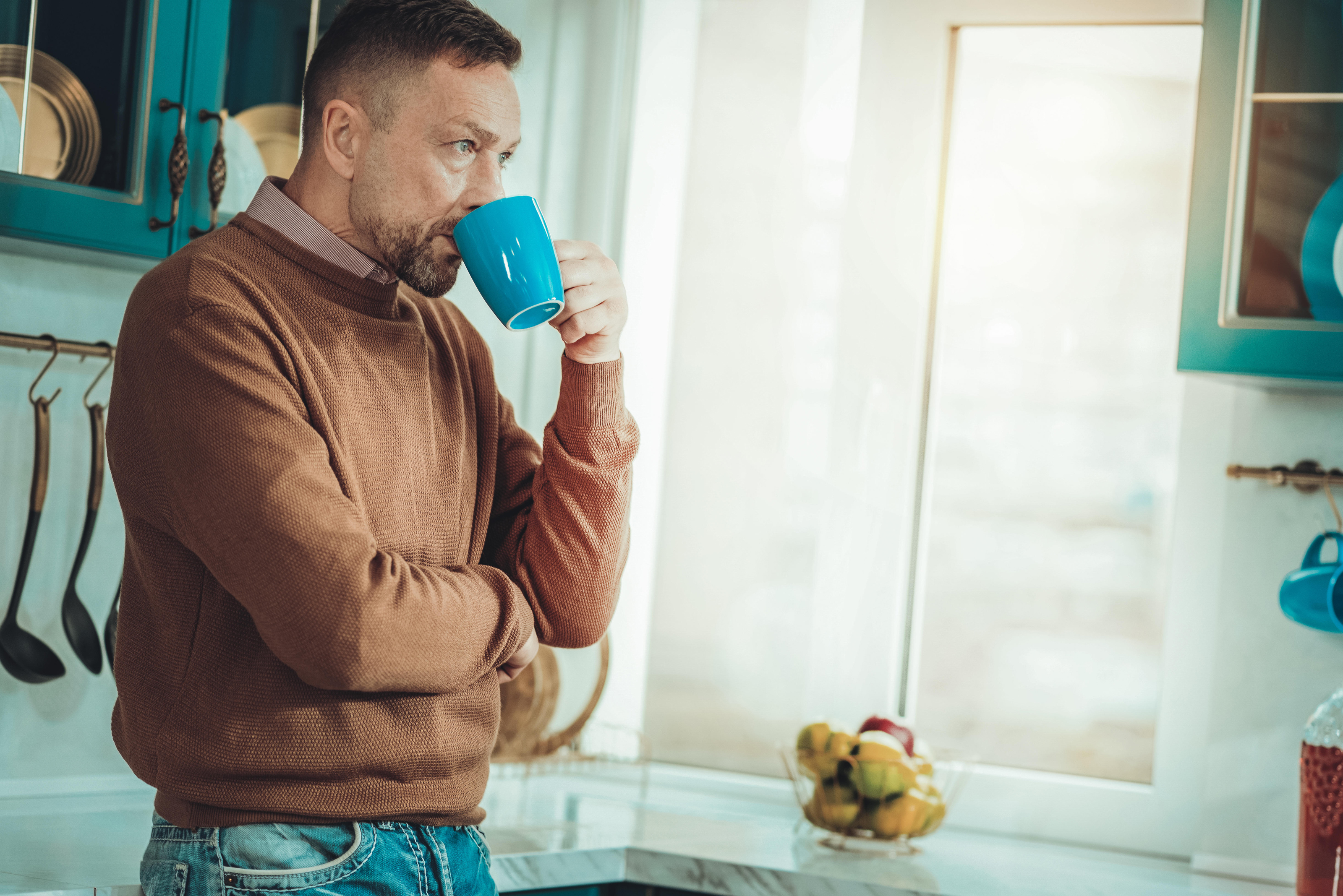 A white man drinking coffee at home