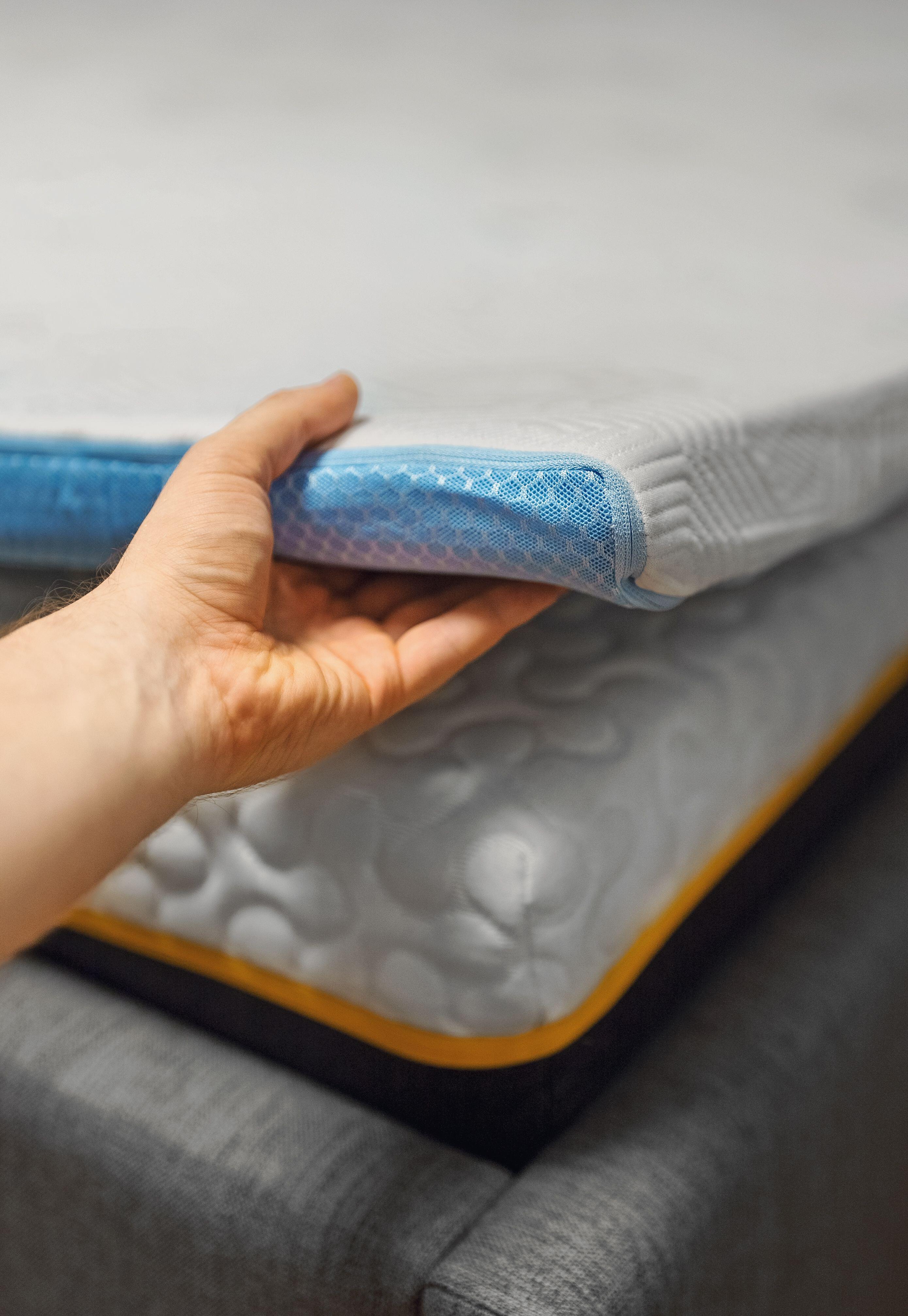 Man hand testing memory foam mattress topper