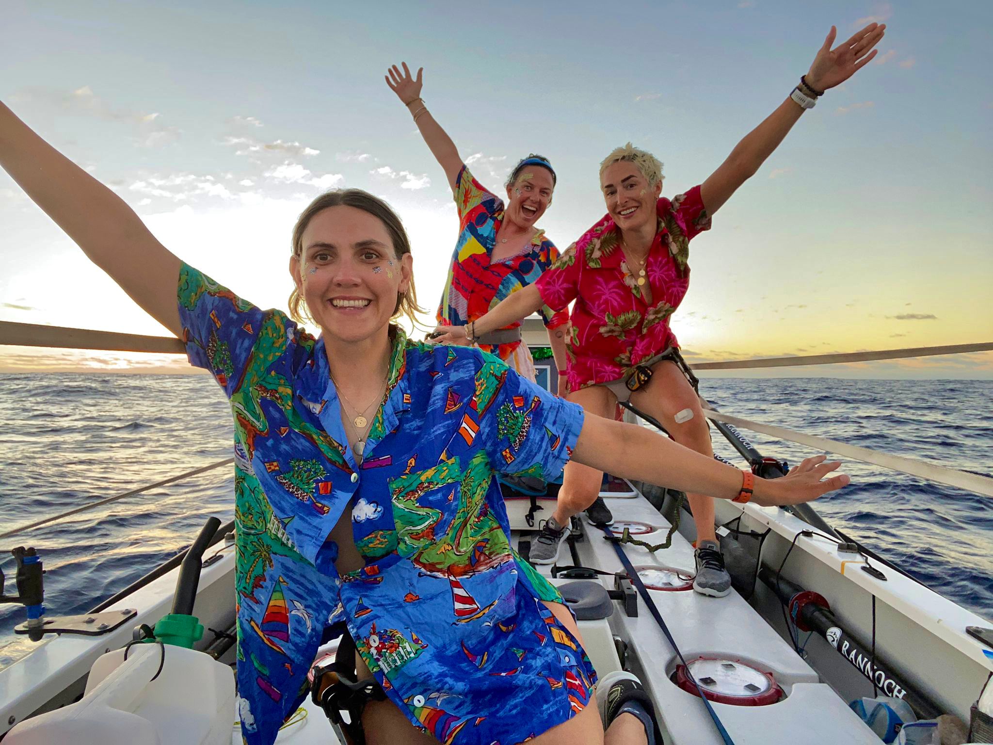 British rowers (front to back) Charlotte Irving, Kat Cordiner and Abby Johnston at sea wearing Hawaiian shirts during their 42-day voyage across the Atlantic.