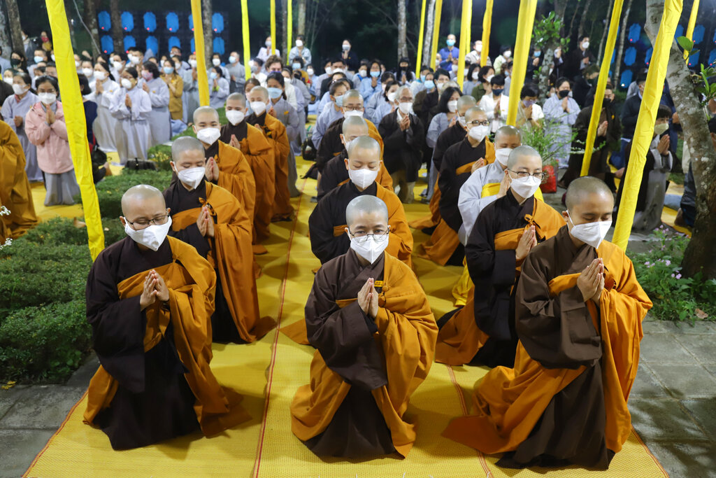 Monks and Thich Nhat Hanh followers pray during the funeral of the Vietnamese Buddhist monk in Hue, Vietnam Saturday, Jan. 29, 2022. A funeral was held Saturday for Thich Nhat Hanh, a week after the renowned Zen master died at the age of 95 in Hue in central Vietnam. (AP Photo/Thanh Vo)