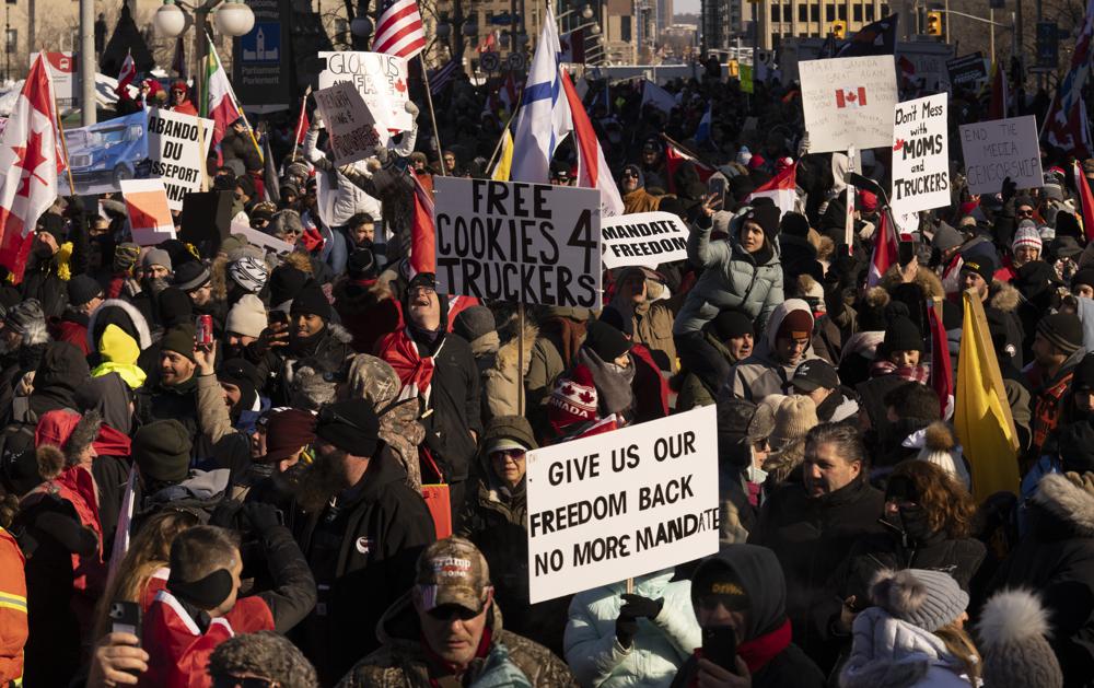 Protesters participating in a cross-country truck convoy protesting measures taken by authorities to curb the spread of COVID-19 and vaccine mandates gather near Parliament Hill in Ottawa on Saturday, Jan. 29, 2022. 