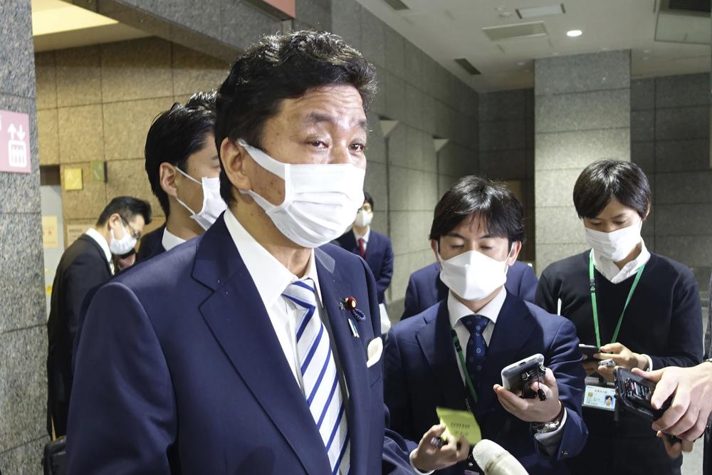 Japanese Defence Minister Nobuo Kishi, left, speaks to media following a report on North Korea's missile launch in Tokyo on Sunday. 