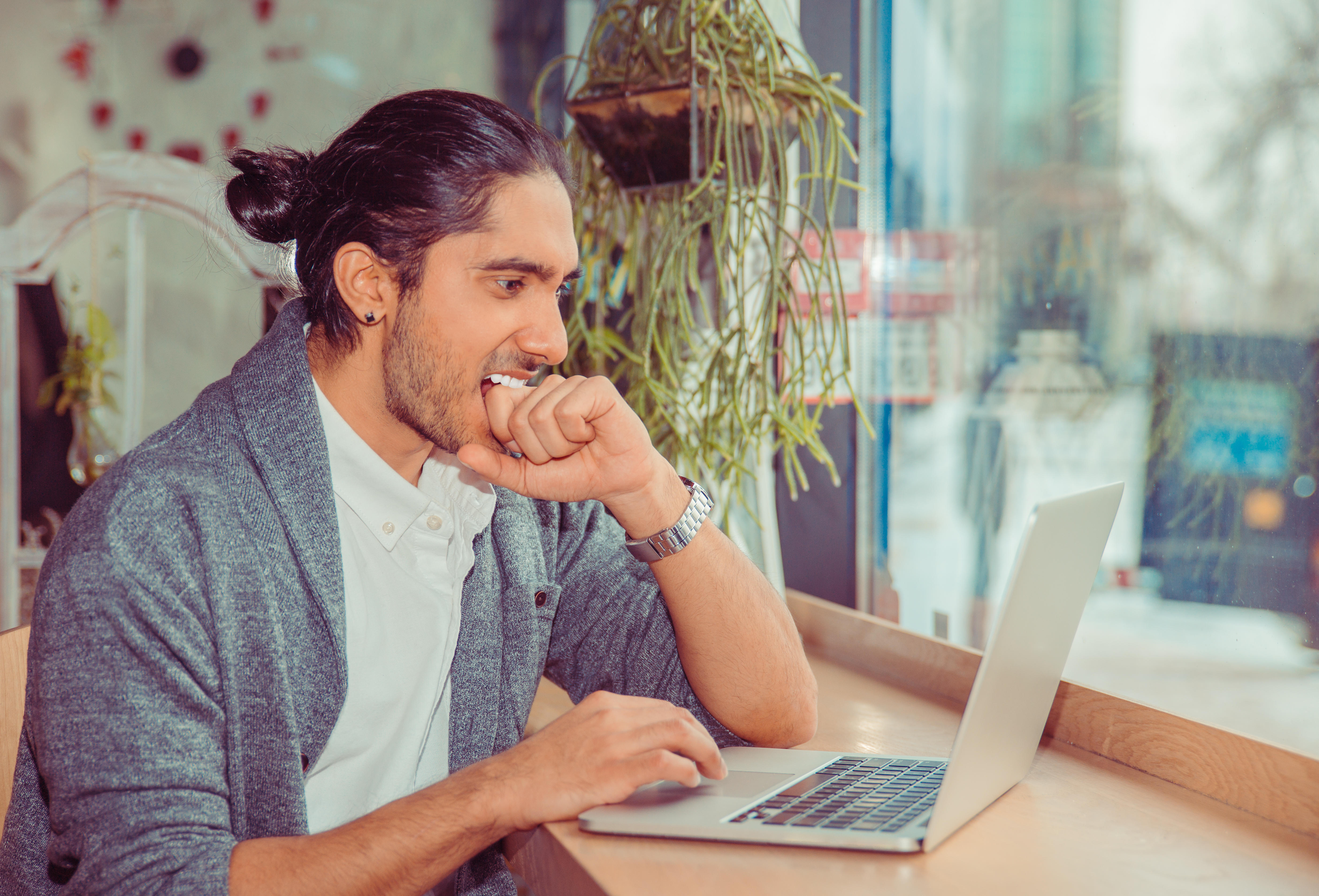 Man with laptop looking nervous 