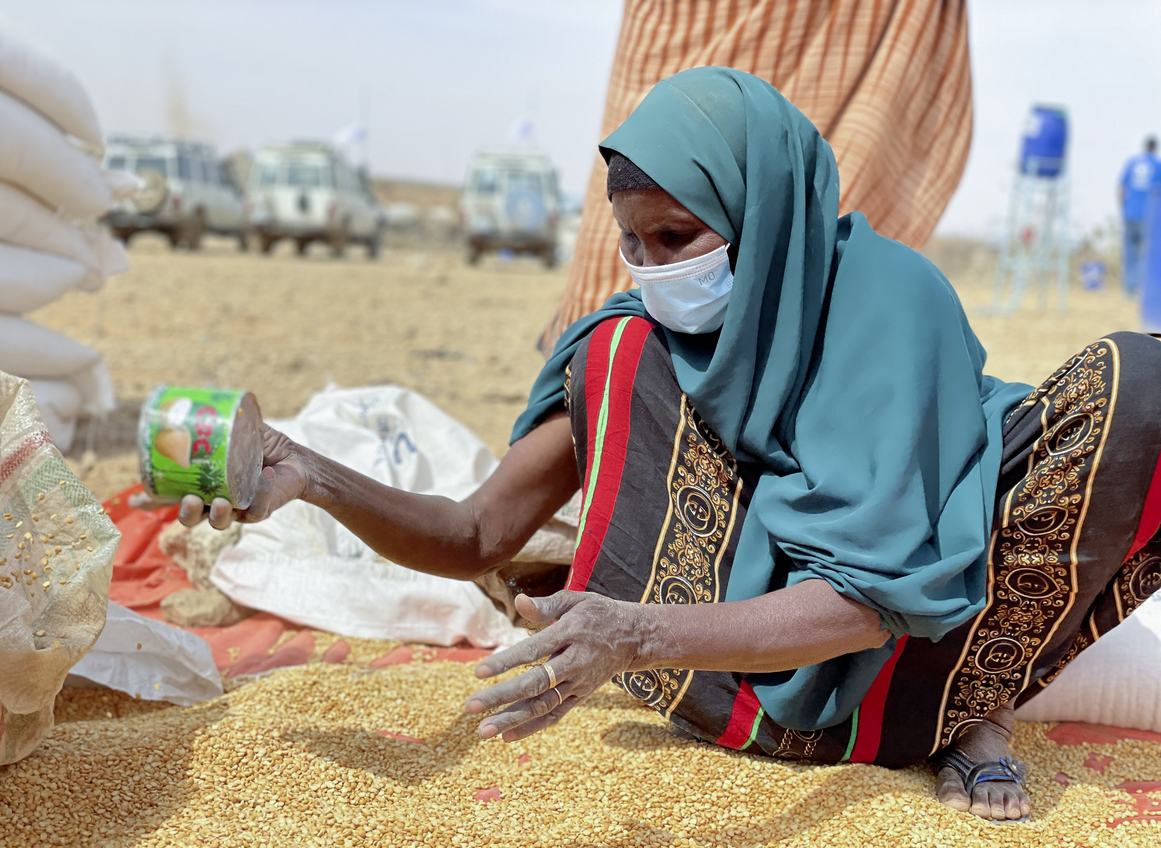 An Ethiopian woman sifts through distributed food supplies