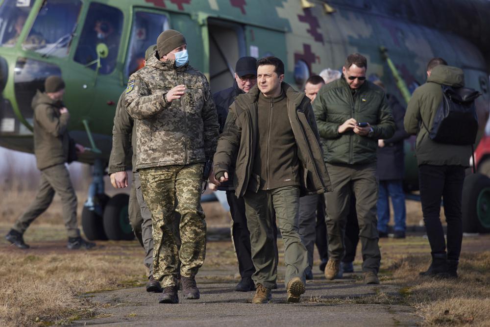 Ukrainian President Volodymyr Zelenskyy, centre, arrives to attend a military drill outside the city of Rivne, northern Ukraine