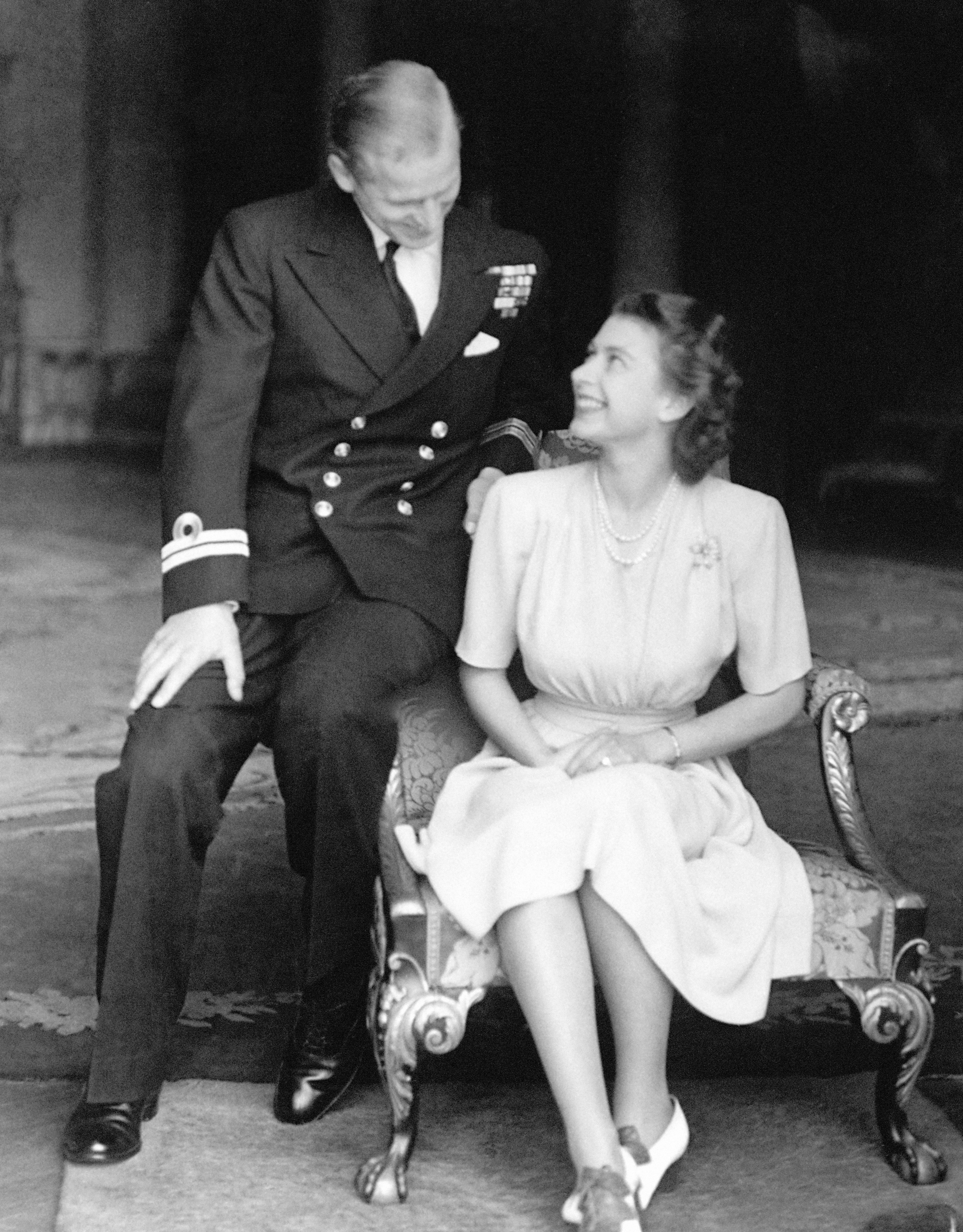 The engagement of Princess Elizabeth to Lieutenant Philip Mountbatten is announced and the happy young couple are pictured together at Buckingham Palace
