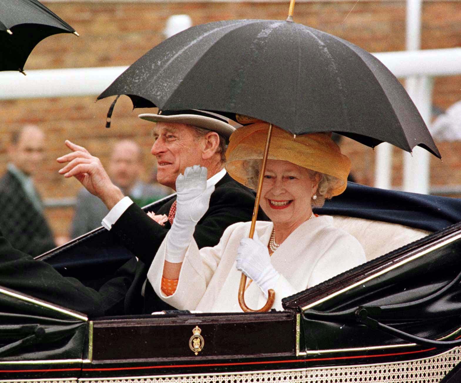 The Queen and Duke of Edinburgh arrive on the course at a rain-swept Royal Ascot