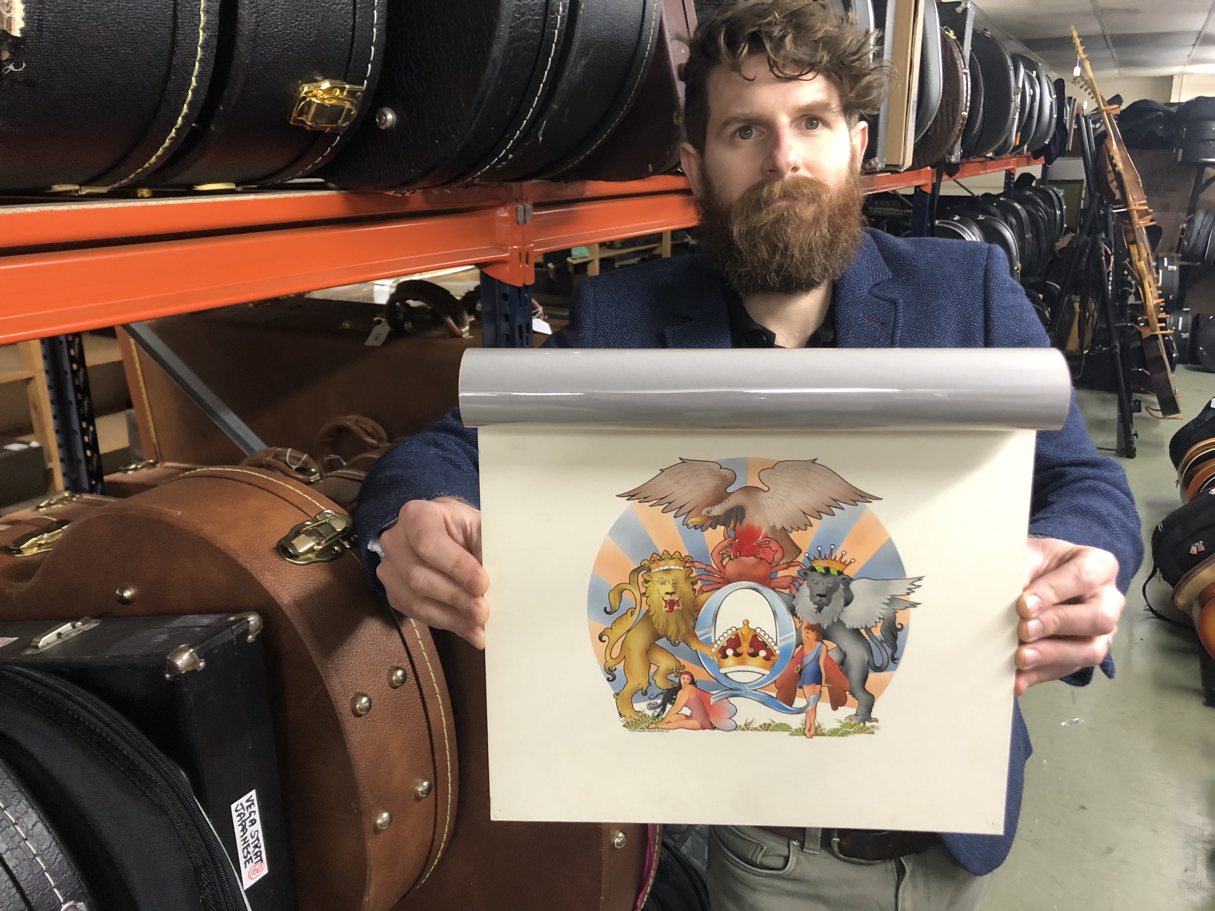 Auctioneer Luke Hobbs with David Costa's original artwork for the 1976 Queen album A Day At The Races (Gardiner Houlgate/PA)