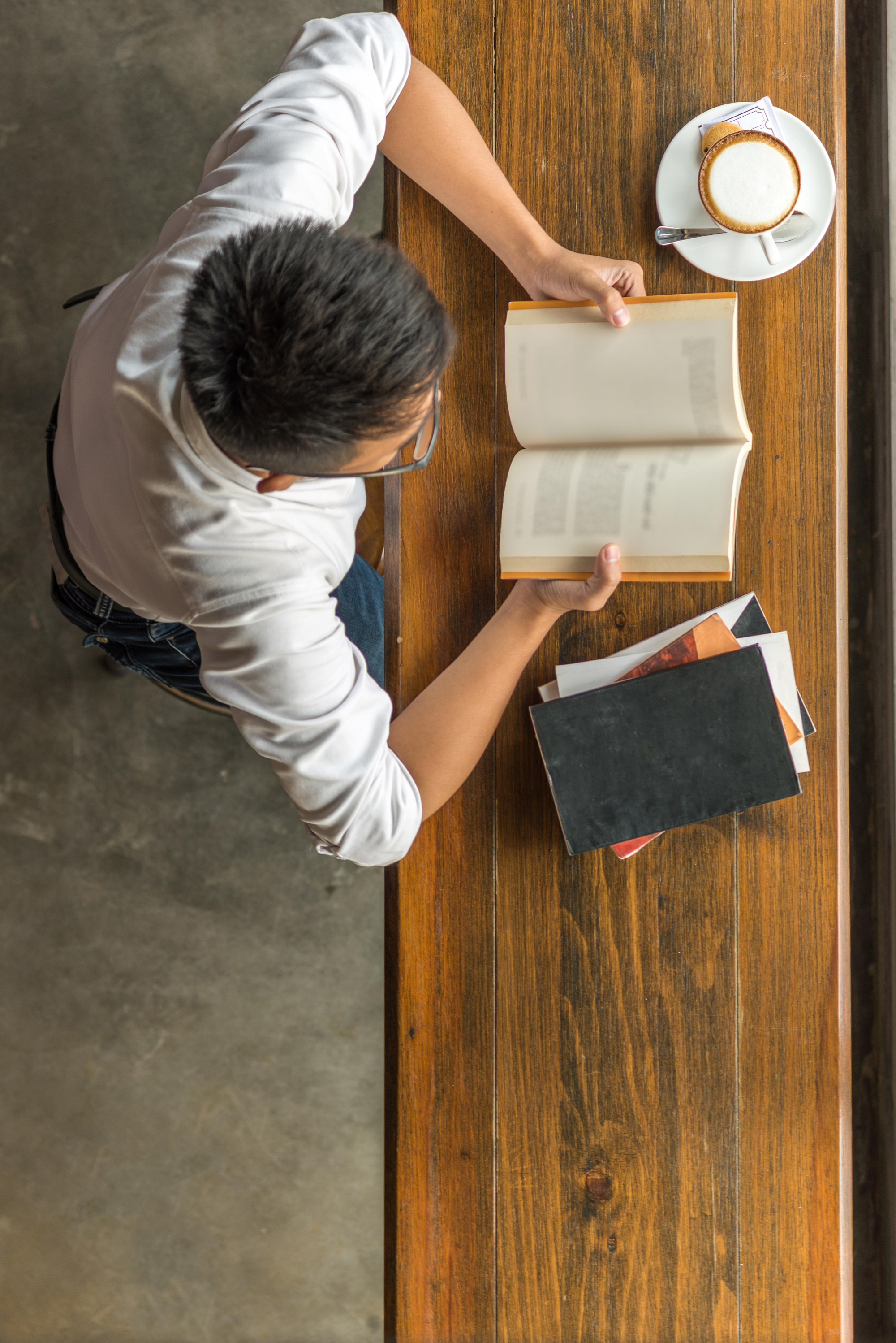 Top view of young man reading book