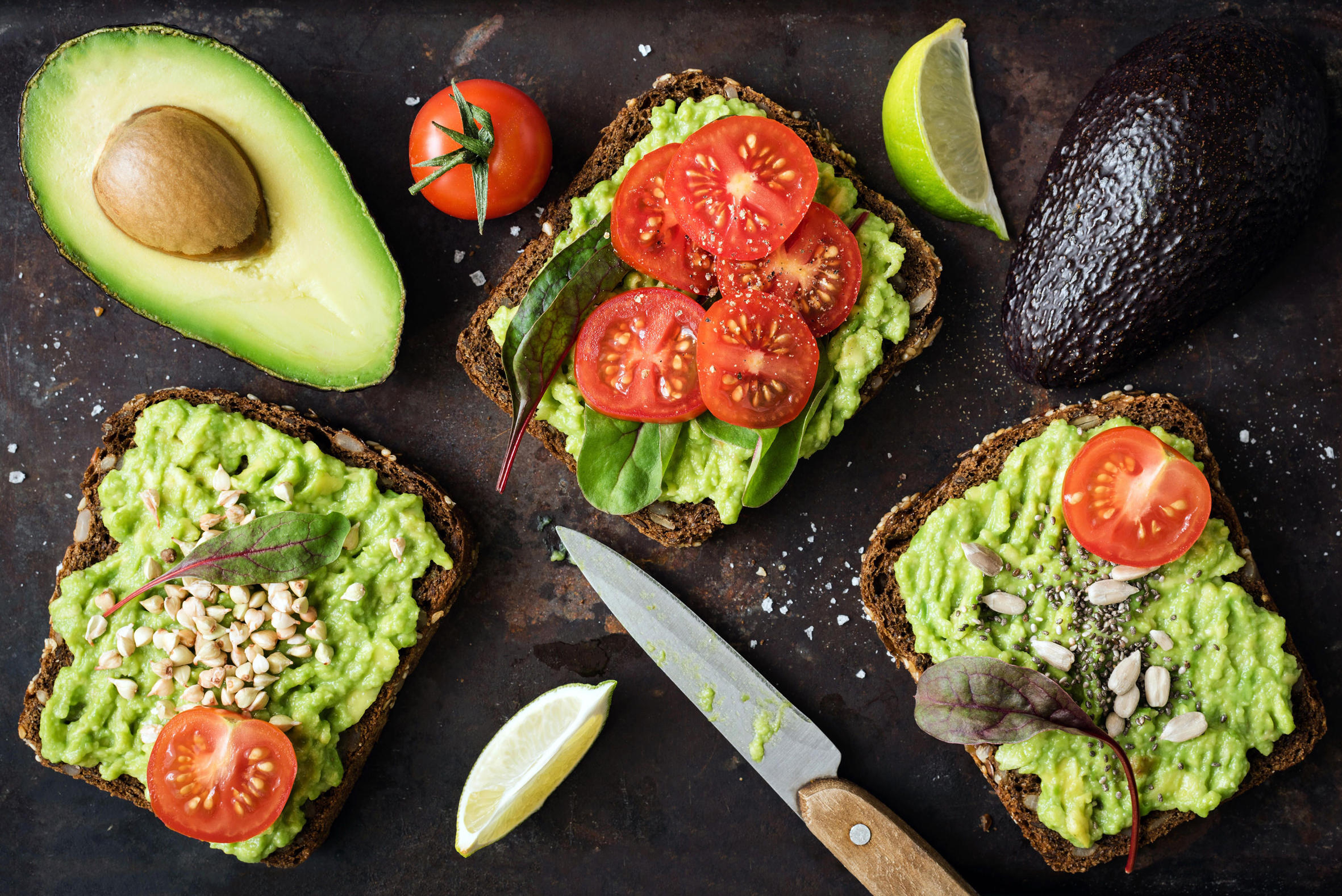 Healthy green veggie toast with avocado, tomato, sprouts and seeds