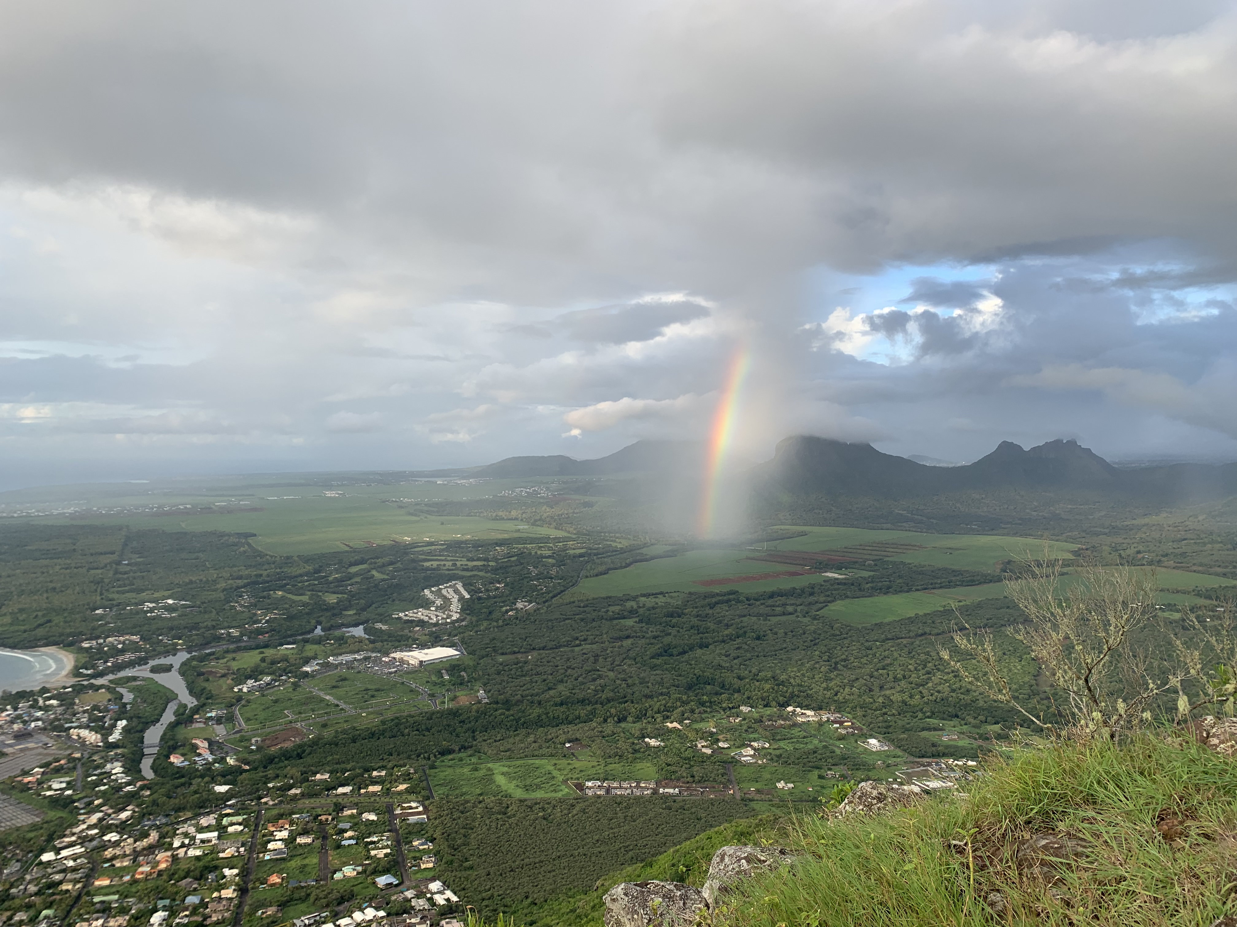 A rainbow breaks out over Tamarin, as seen from part-way up La Tourelle mountain. PA Photo / Ryan Hooper