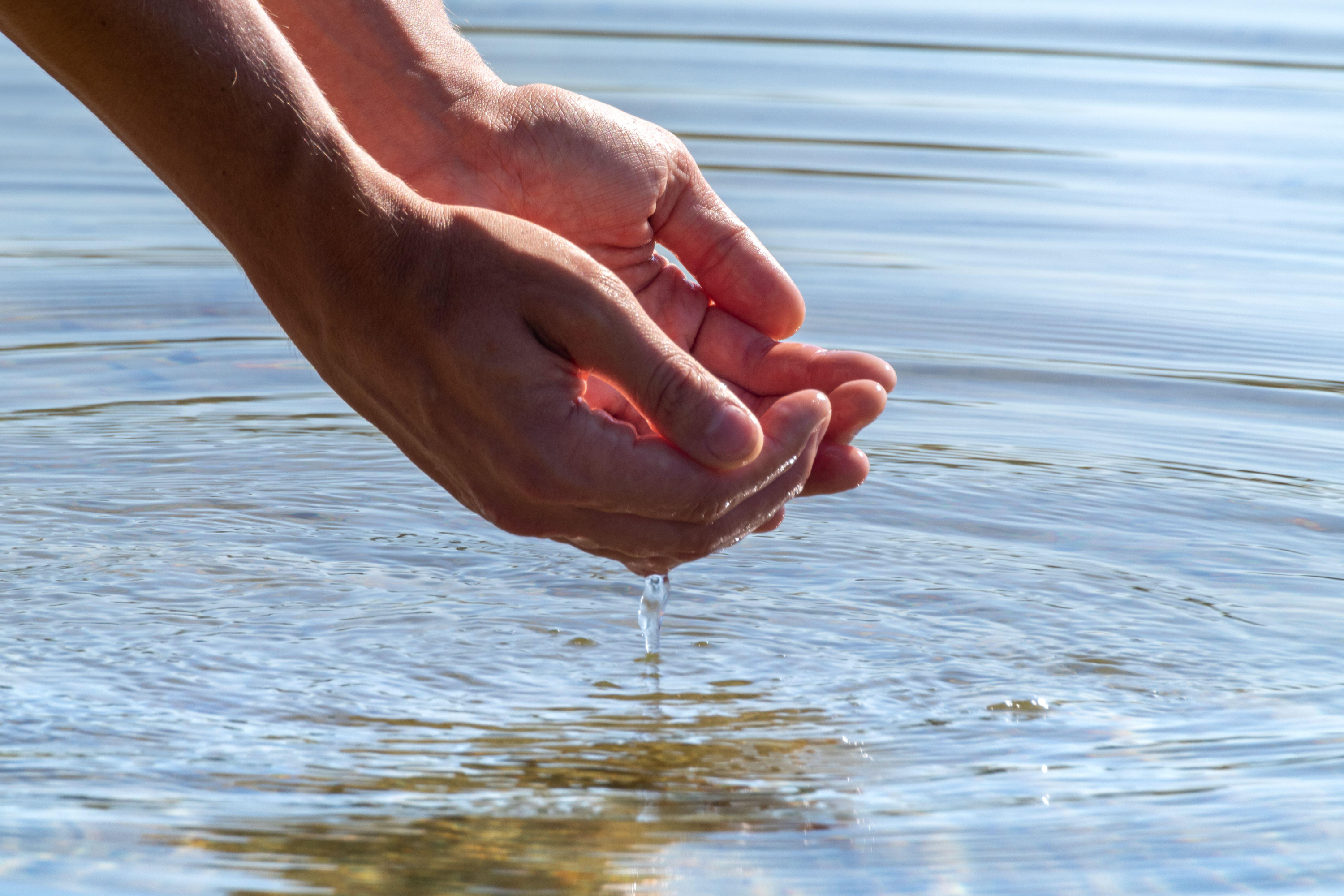 Hands dipped in water (Alamy/PA)