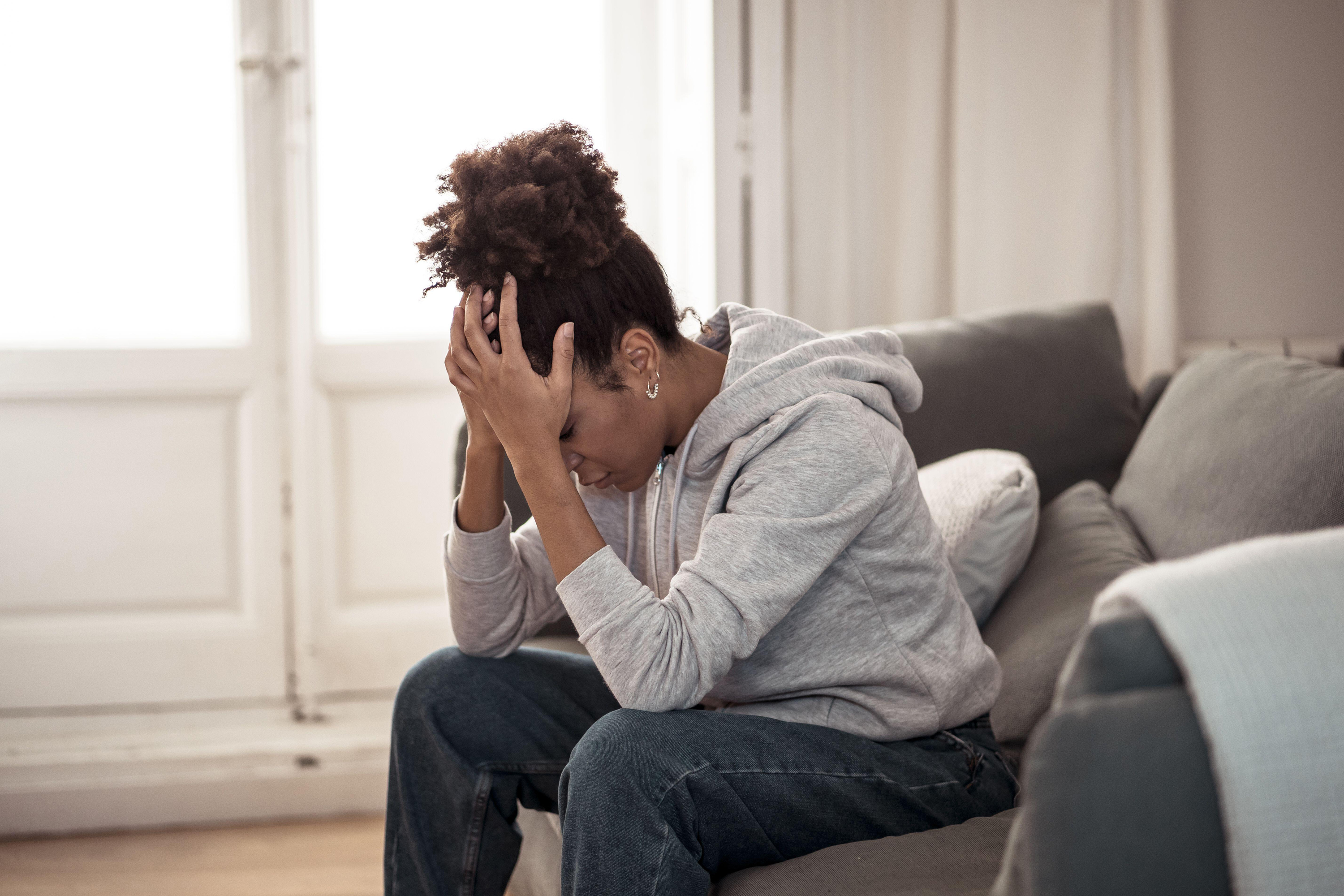 Woman feeling upset sitting on sofa