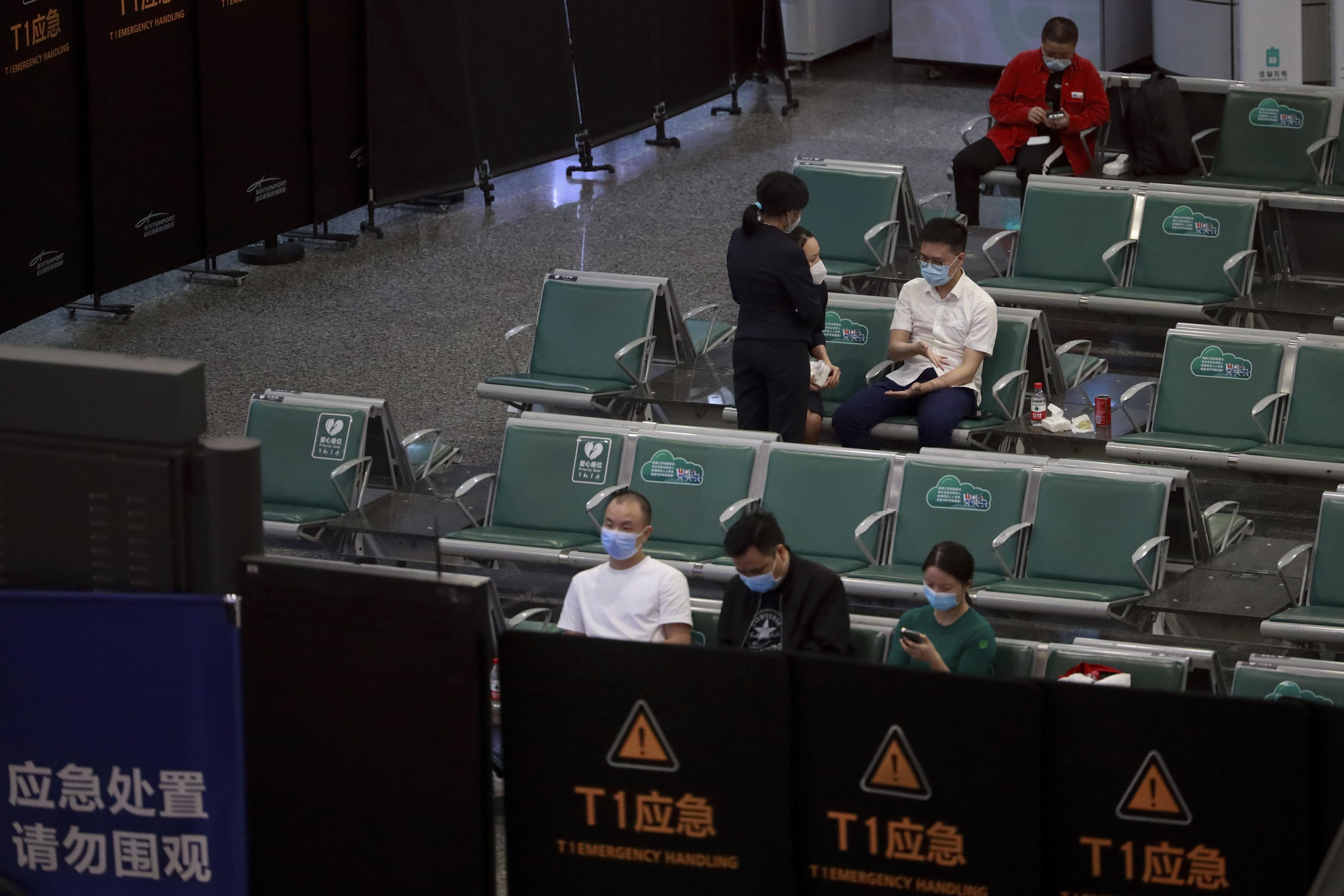 People sit in a temporarily cordoned off area for the relatives of the victims aboard China Eastern's flight MU5735, in Guangzhou Baiyun International Airport in Guangzhou, capital of south China's Guangdong Province