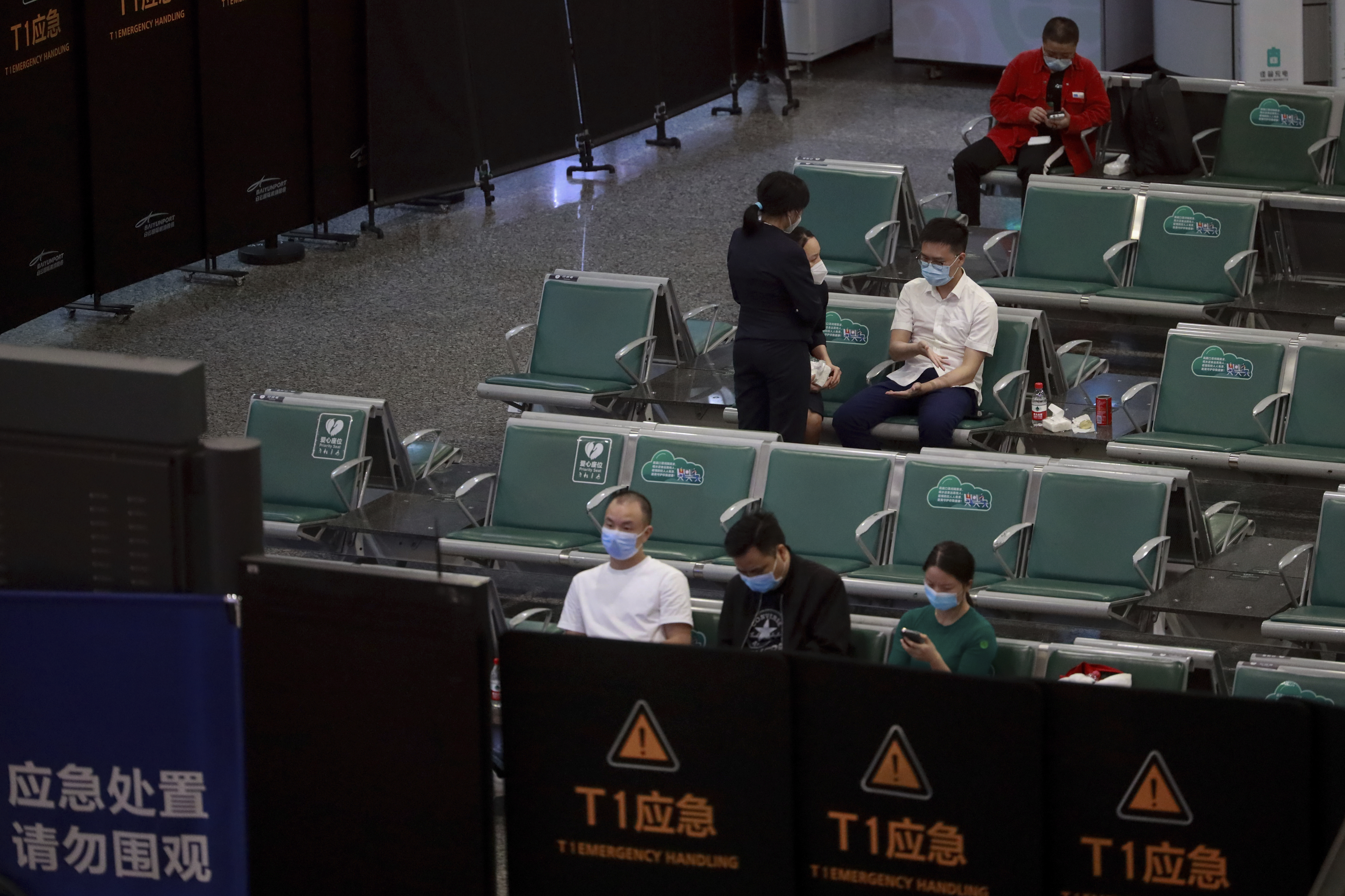 People sit in a temporarily cordoned off area for the relatives of the victims aboard China Eastern's flight MU5735, in Guangzhou Baiyun International Airport in Guangzhou, capital of south China's Guangdong Province 