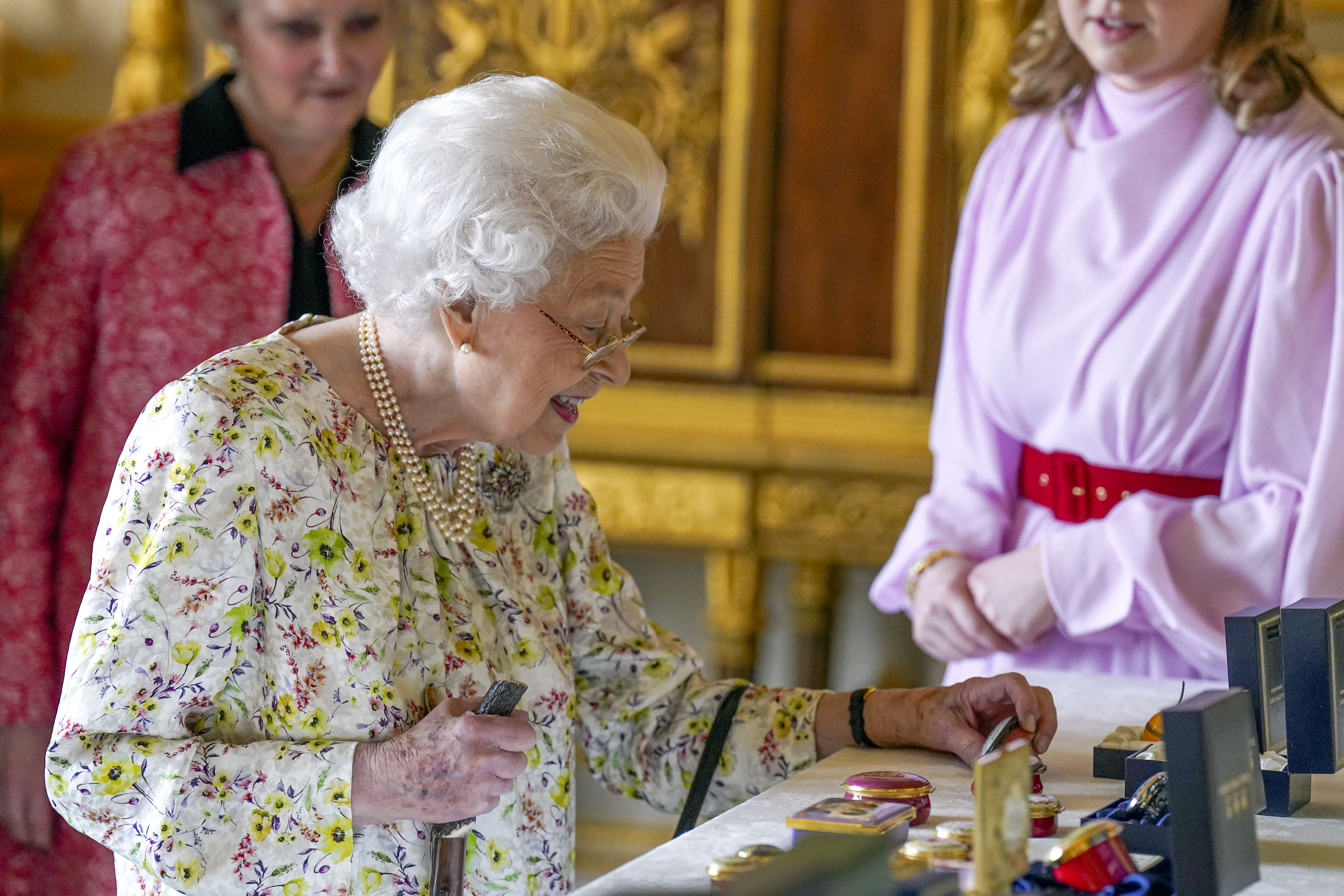 The Queen examining the enamelled boxes 