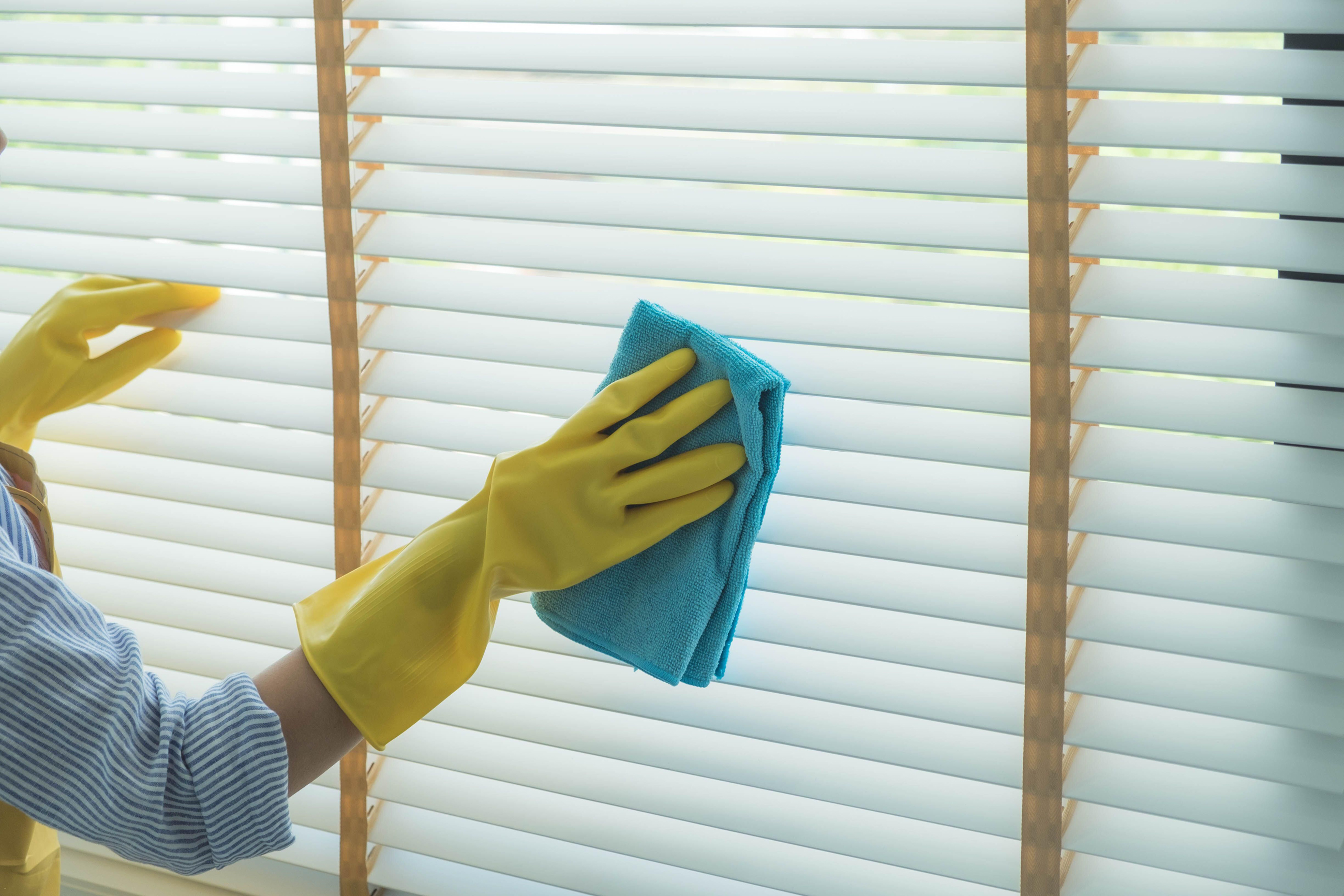 Woman cleaning blinds