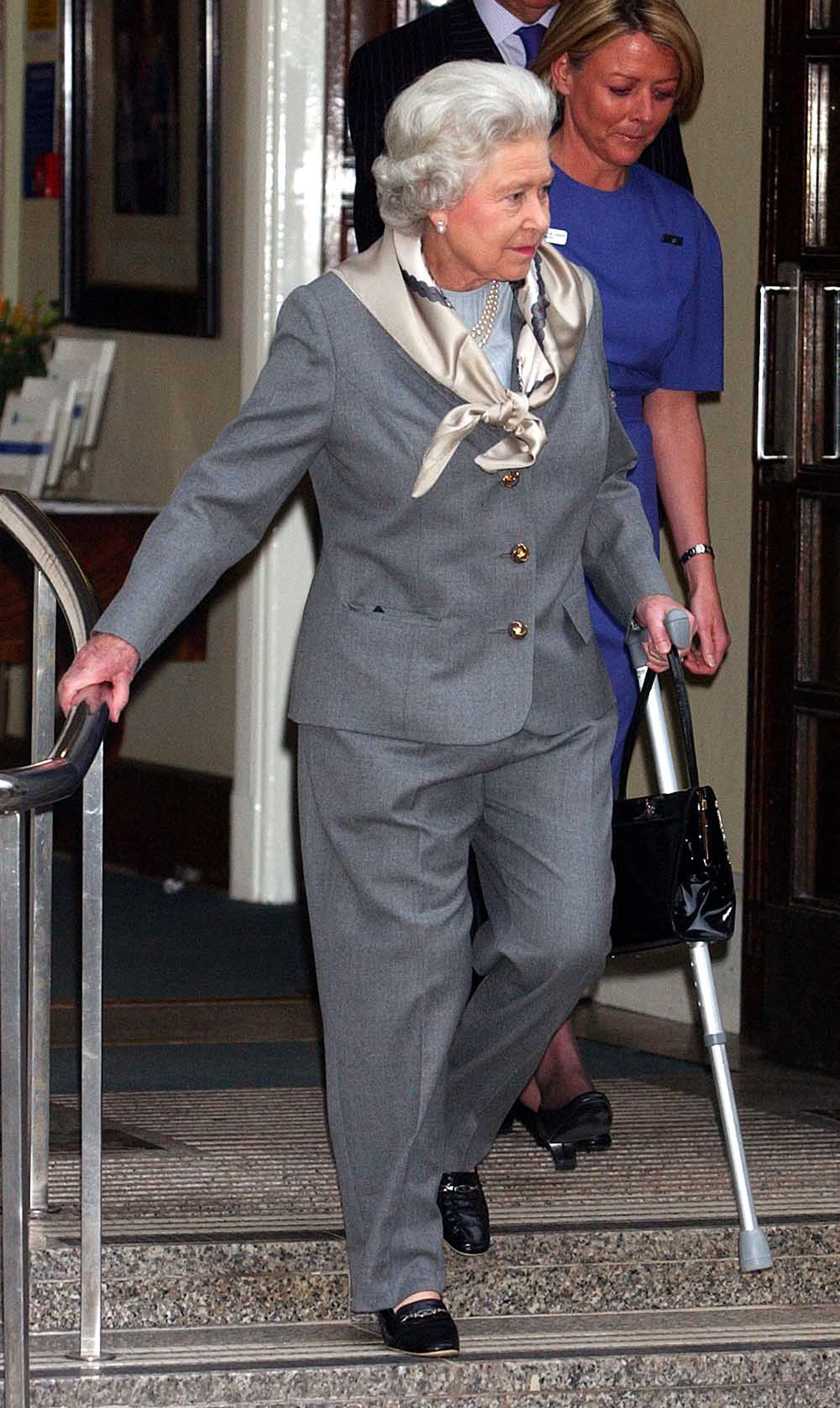 The Queen walks with a stick as she leaves the King Edward VII Hospital in 2003