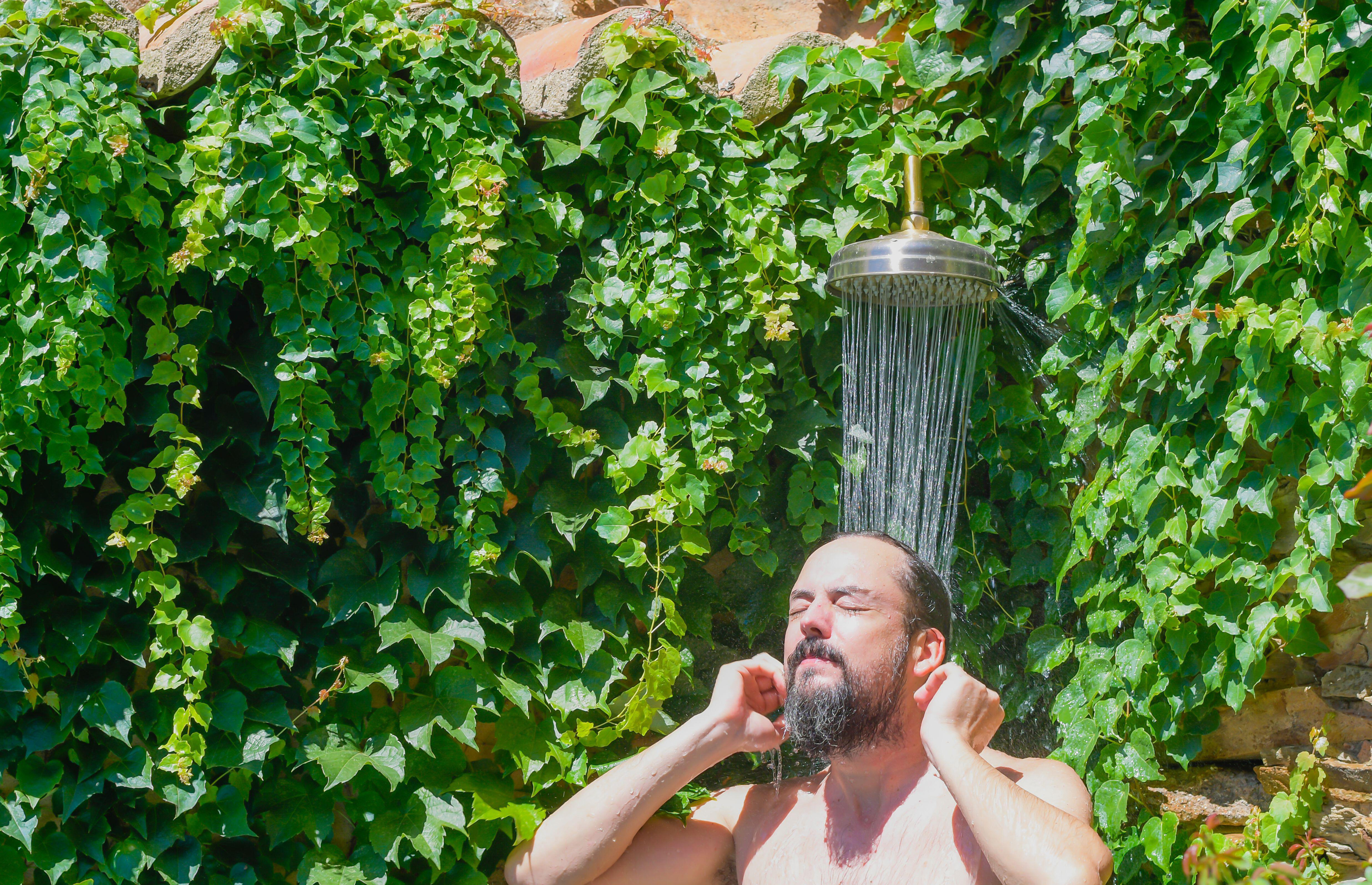 Man taking an outdoor shower (Alamy/PA)