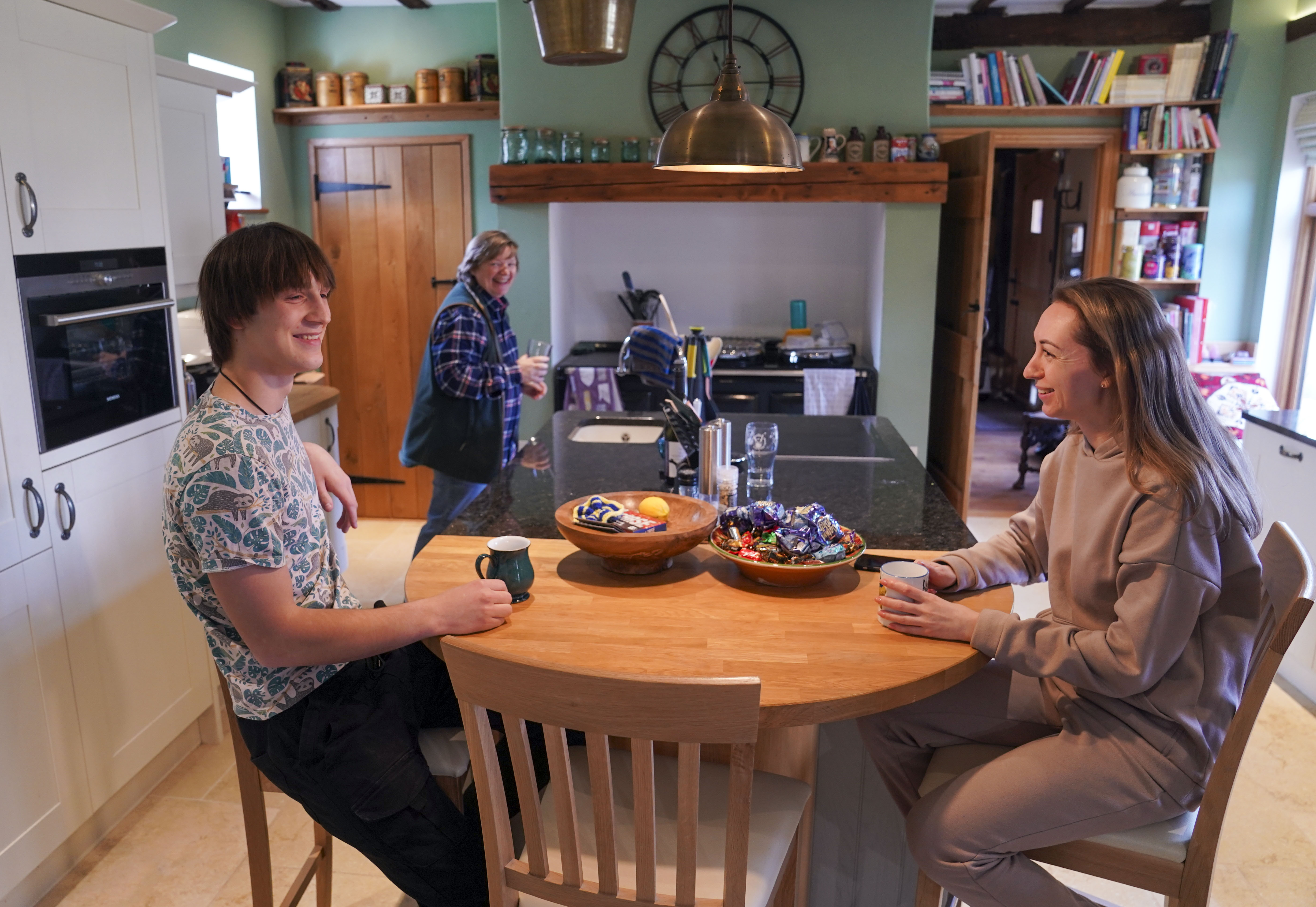 Ukrainian refugees Yaroslav Kryvoshyia (left) and Irina Kryvoviaz (right) with their host Sarah Allen-Stevens (centre) as they settle into their new home in North Moreton, Oxfordshire
