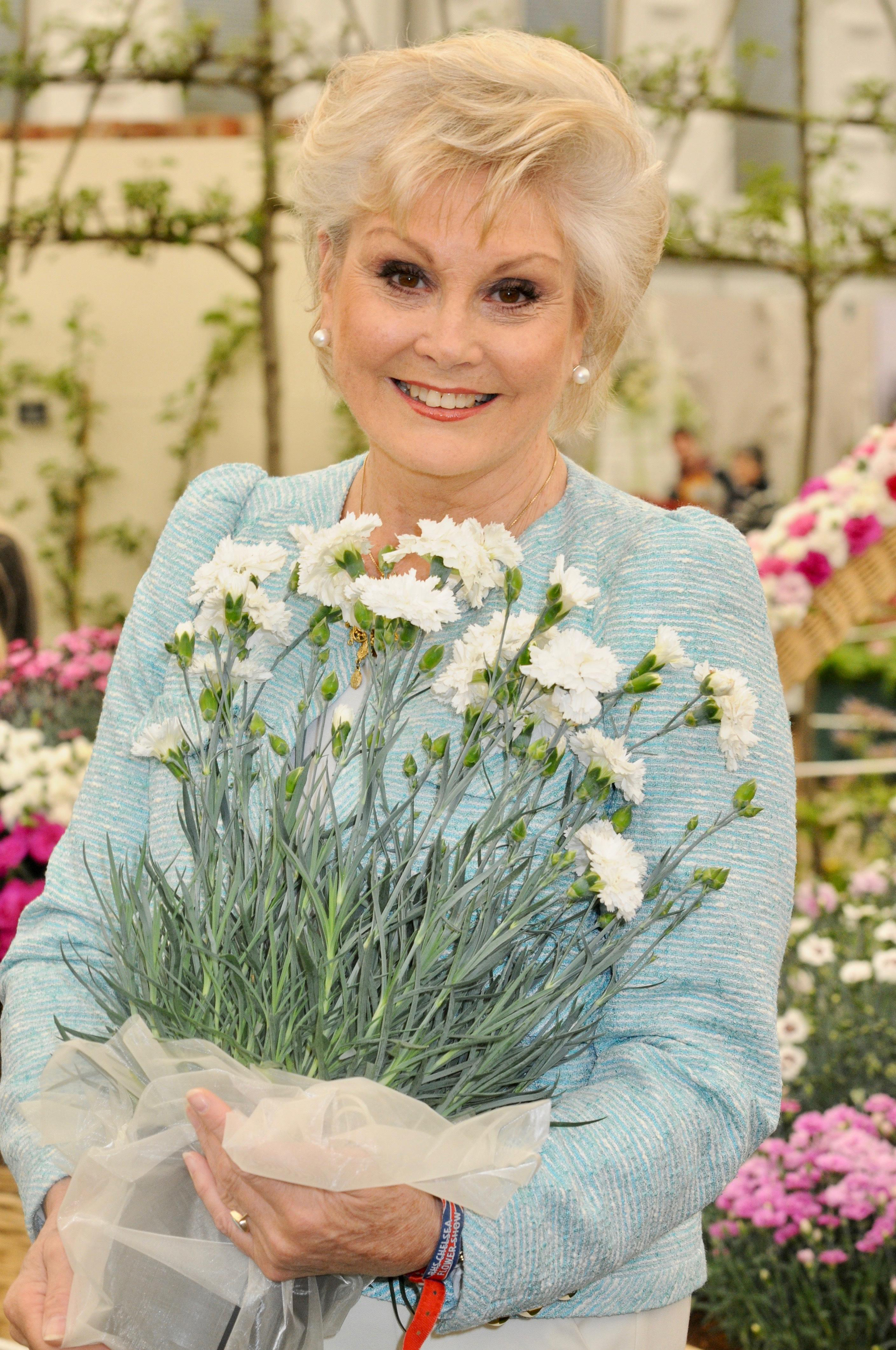 Angela Rippon carrying flowers