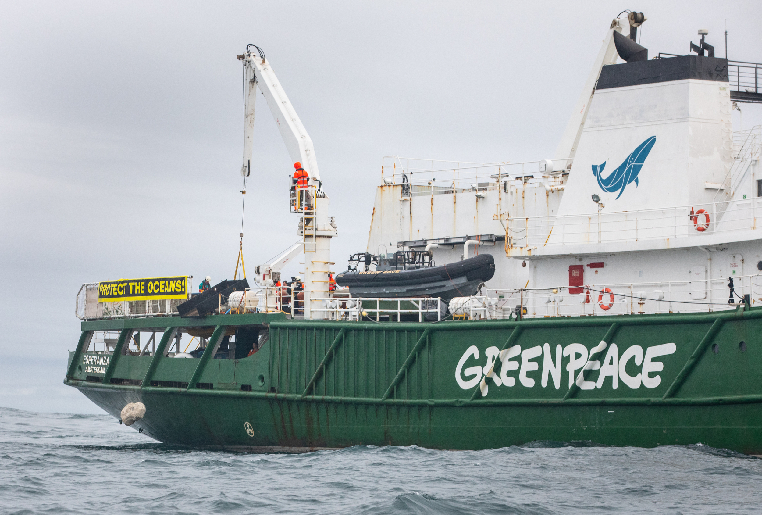 A boulder falls into the North Sea from the Greenpeace ship, Esperanza