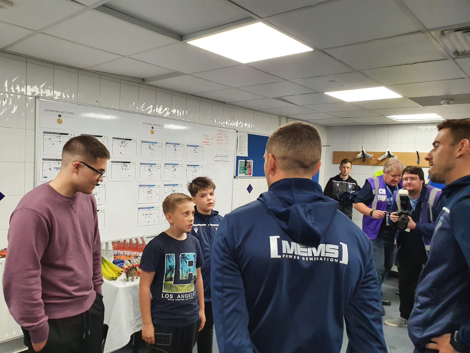 Ukrainian refugee Daniel Lysak (third from left) enjoys a tour of Gillingham's stadium with new friend Freddie (second from left)